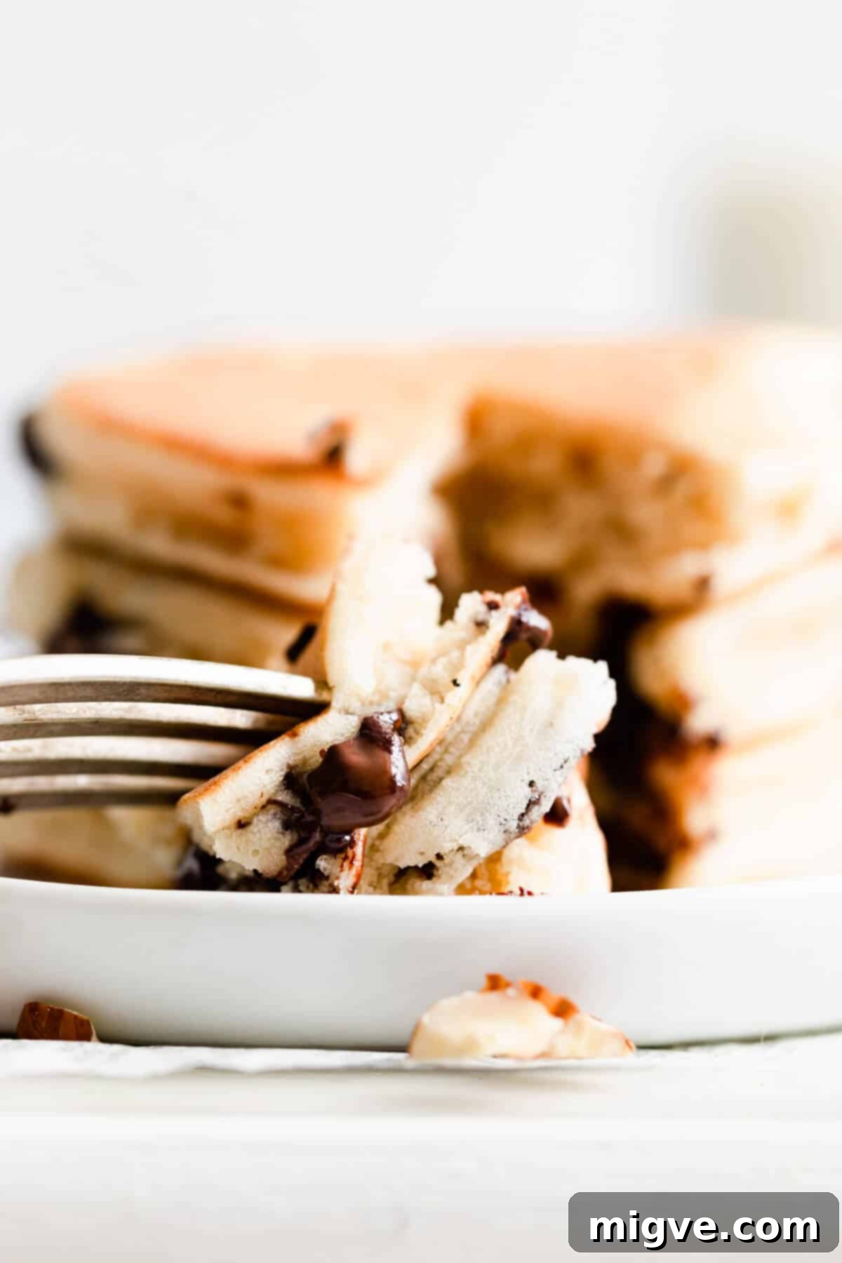 Caramelized Banana Hazelnut Stack 12 Super close-up of a perfectly sliced pancake on a fork, revealing its fluffy interior and a hint of filling