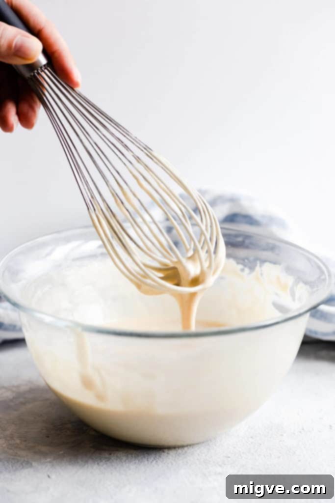 Caramelized Banana Hazelnut Stack 9 Side close-up of thick pancake batter dripping from a whisk, illustrating ideal consistency