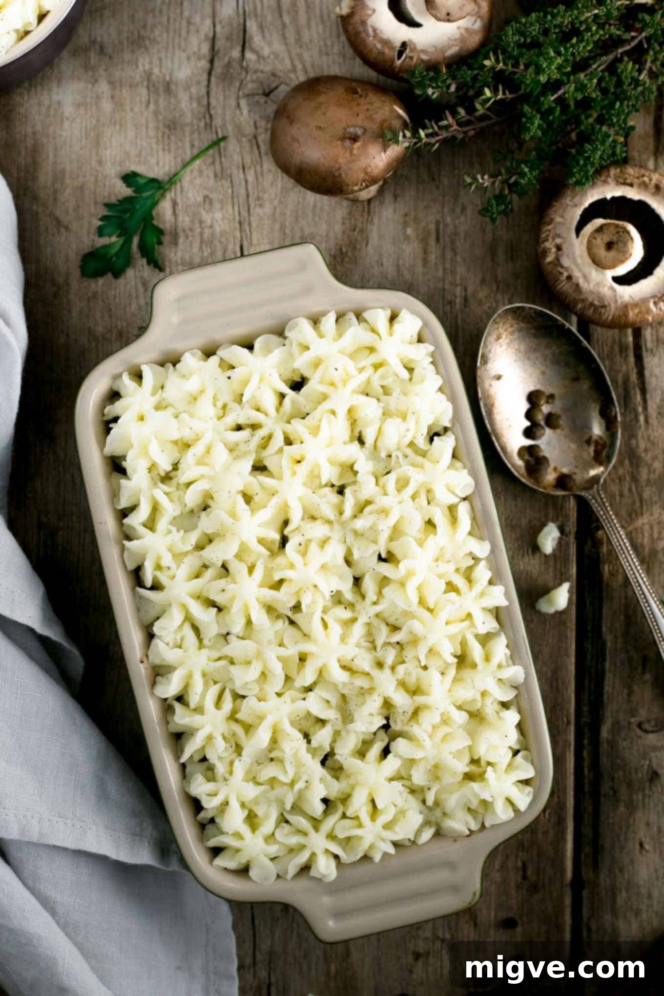 A single mini lentil shepherd's pie, freshly baked, with a golden-brown mashed potato swirl, ready to be served as a wholesome vegan meal.