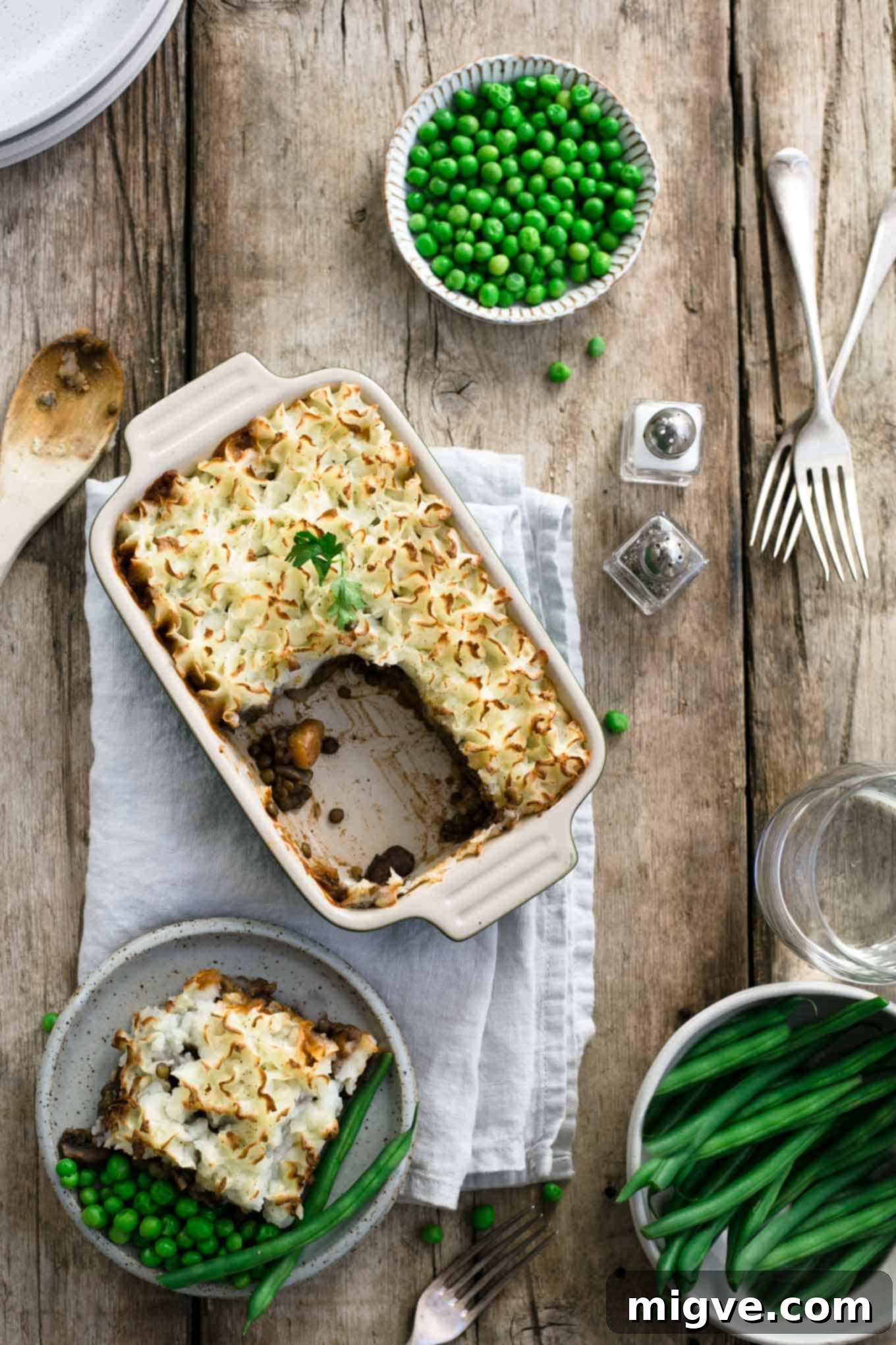 A batch of mini lentil shepherd's pies in various stages of preparation, ready for the oven, emphasizing the homemade quality.