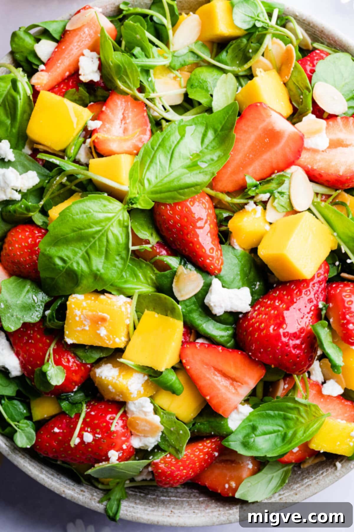 top down super close up at strawberry mango salad with toasted almonds on top