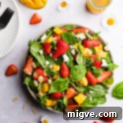 overhead view of strawberry mango salad topped with feta cheese