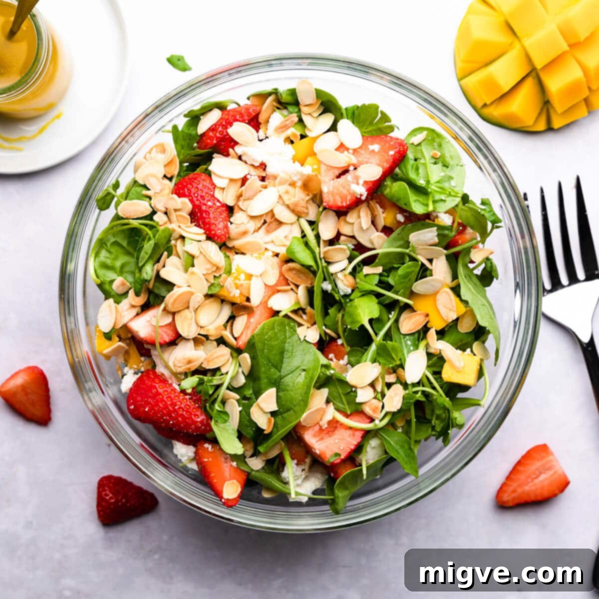 overhead photo showing salad ingredients in a bowl with toasted almonds on top