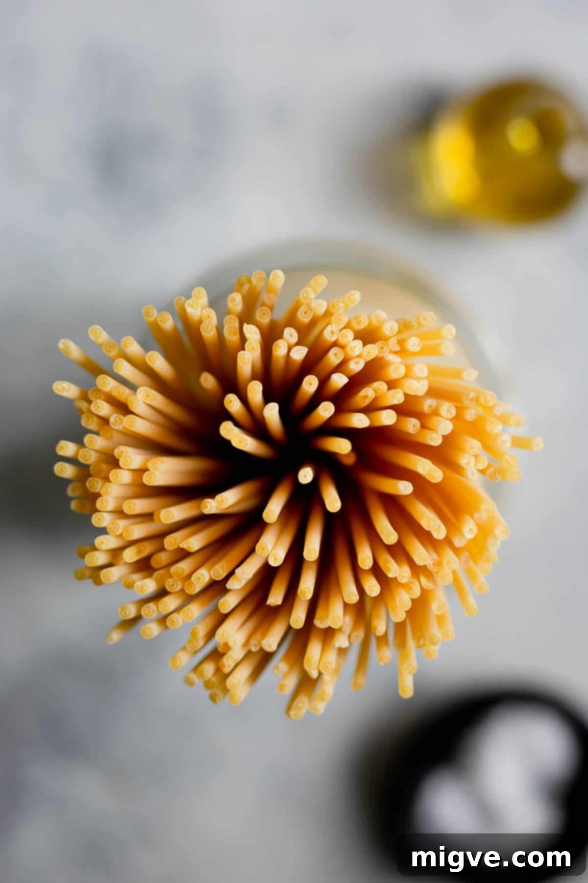 Overhead shot of dry bucatini pasta strands, highlighting their hollow centers and unique texture