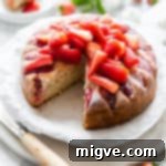 Top-side angle of fresh strawberry yogurt cake with a slice cut out