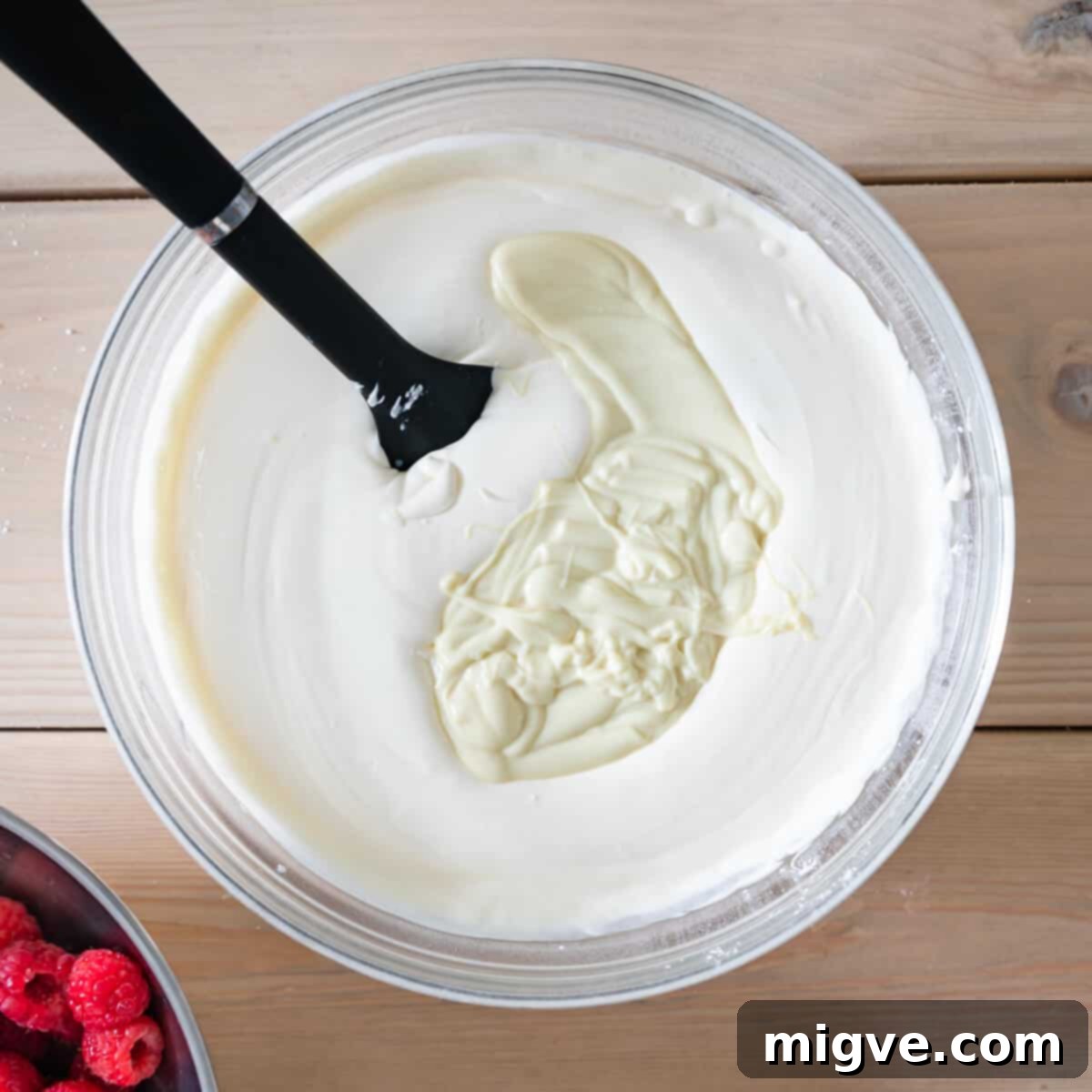 mixing bowl with whipped cream and mascarpone cheese and melted white chocolate.