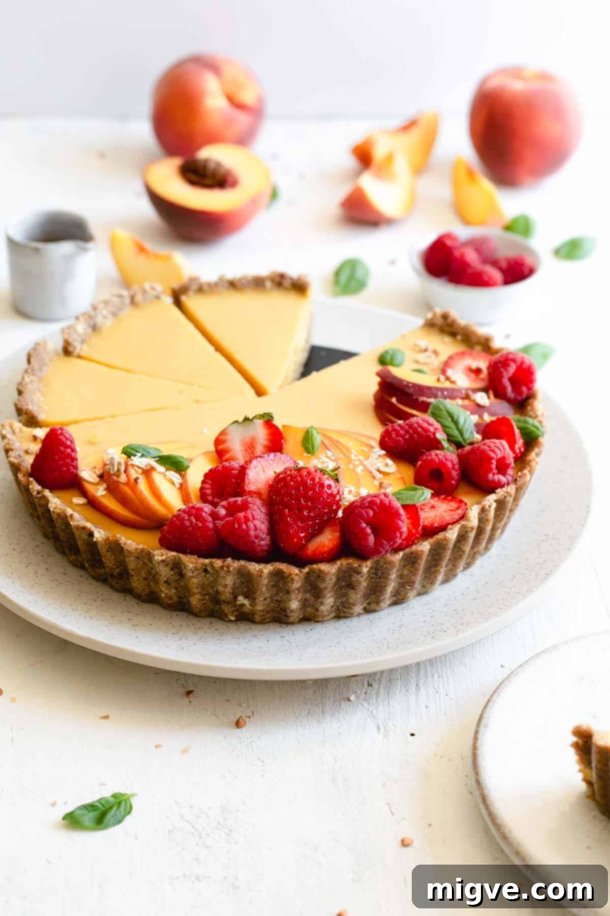 Wholesome Golden Peach Tart 9 Front on photo of vegan peach tart topped with fresh peach and summer berries