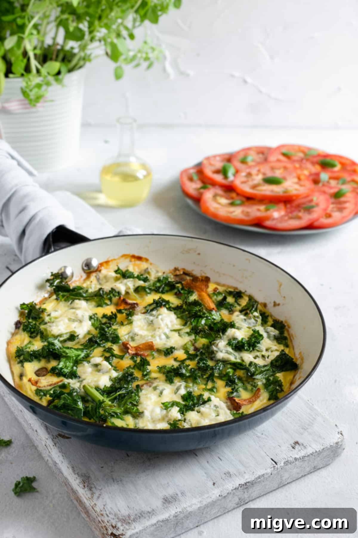 Side shot of the mushroom and kale frittata baking in the pan, golden brown and set.