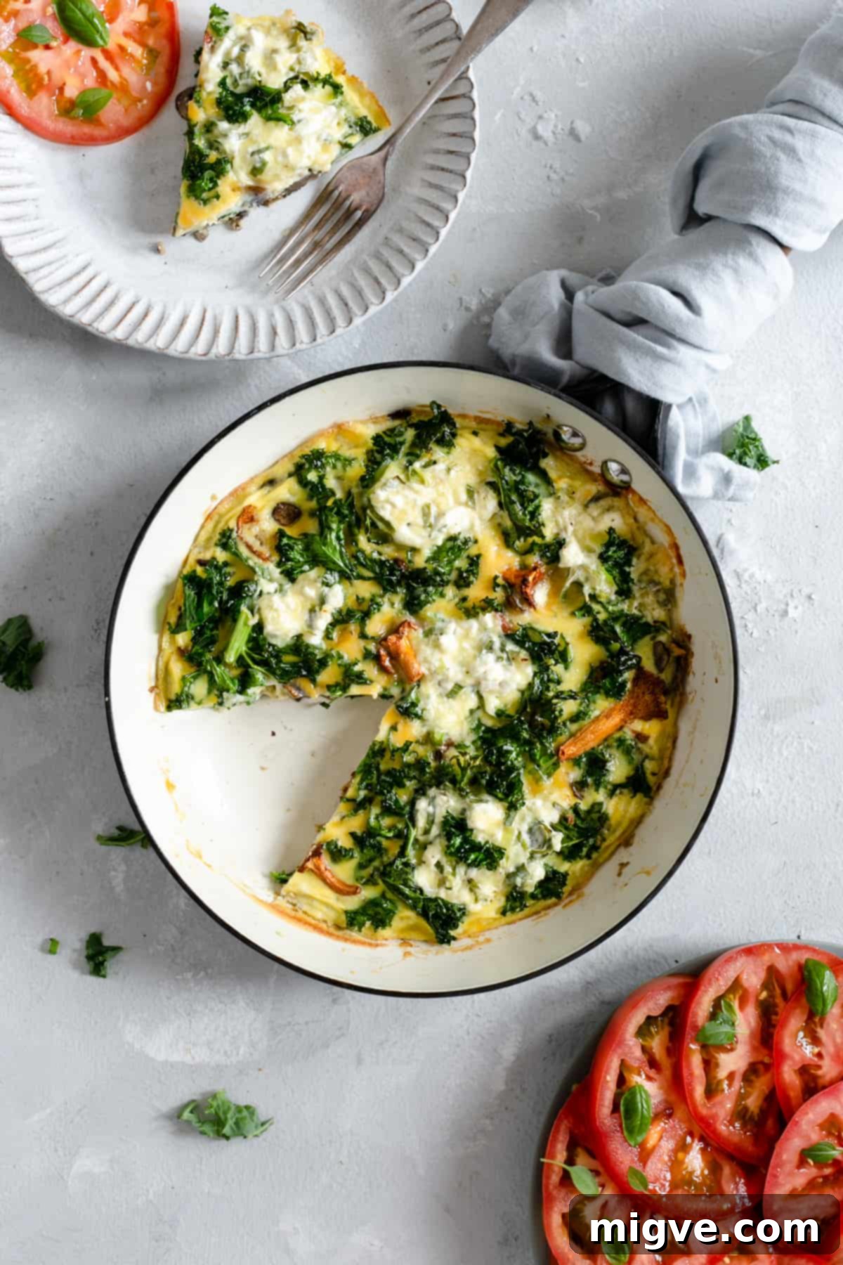 Frying pan with a slice cut out of the mushroom and kale frittata.