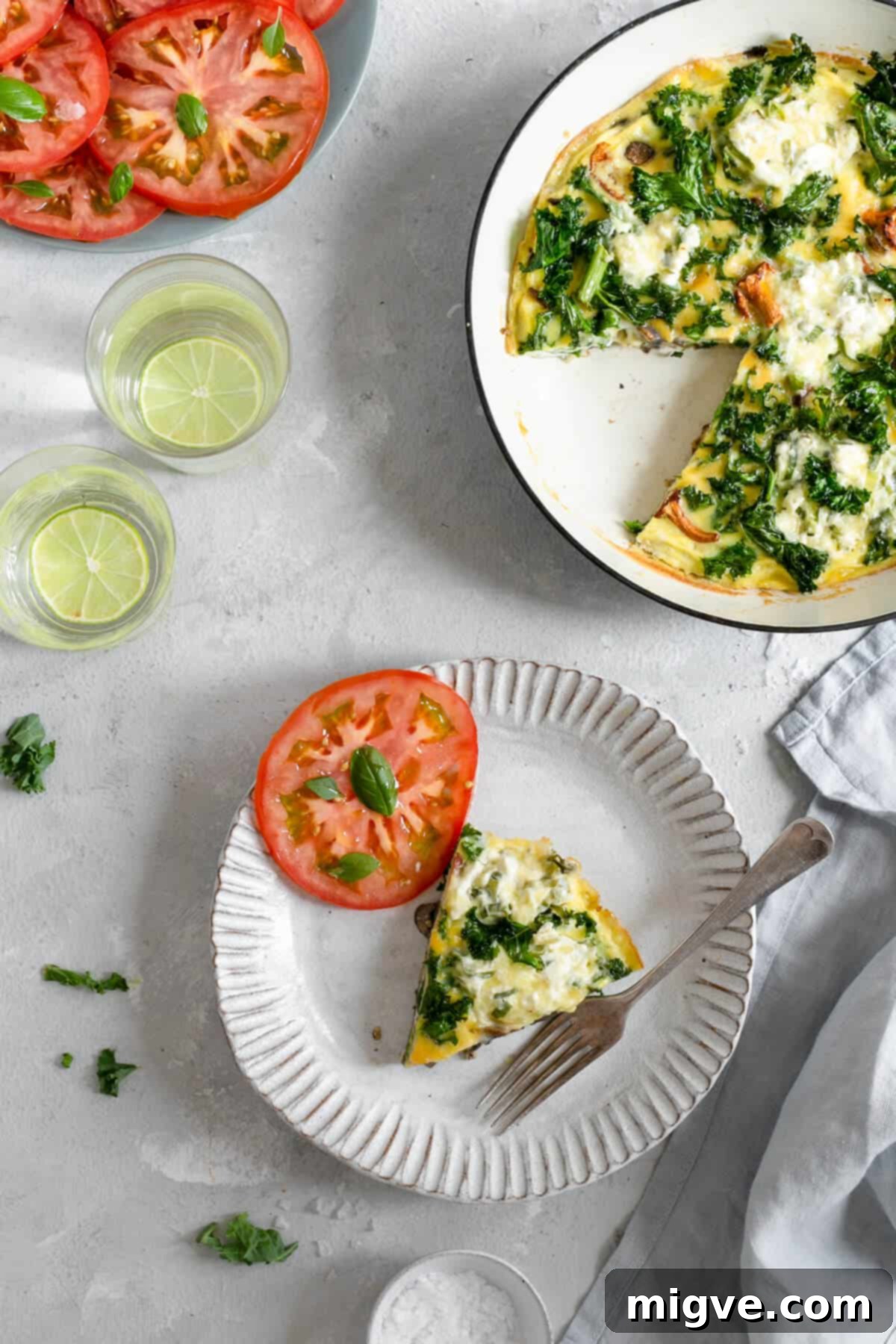 A single slice of mushroom and kale frittata served on a white plate.