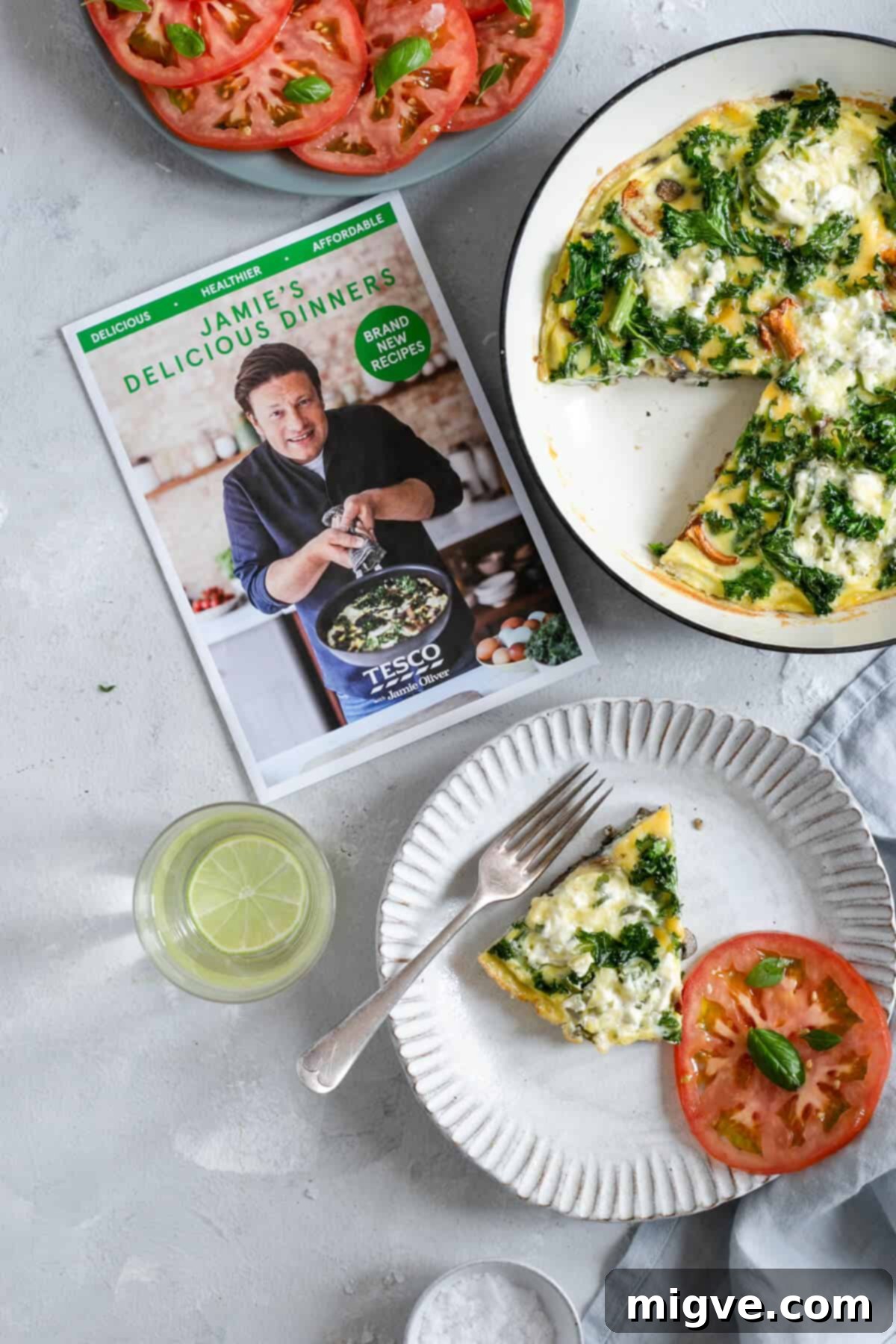 Slice of mushroom and kale frittata with tomato salad on the plate, ready to be enjoyed.