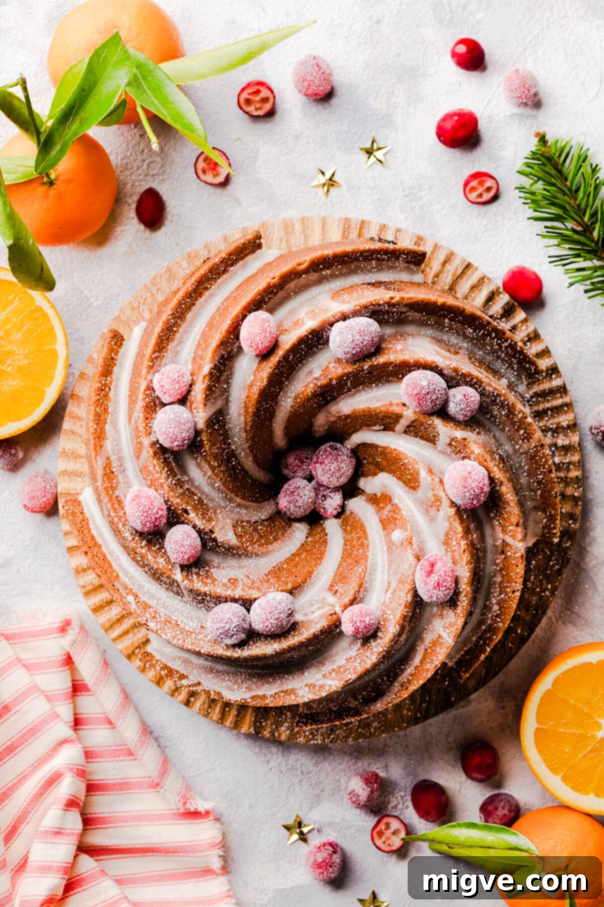 cranberry and orange bundt cake on a wooden cake board.
