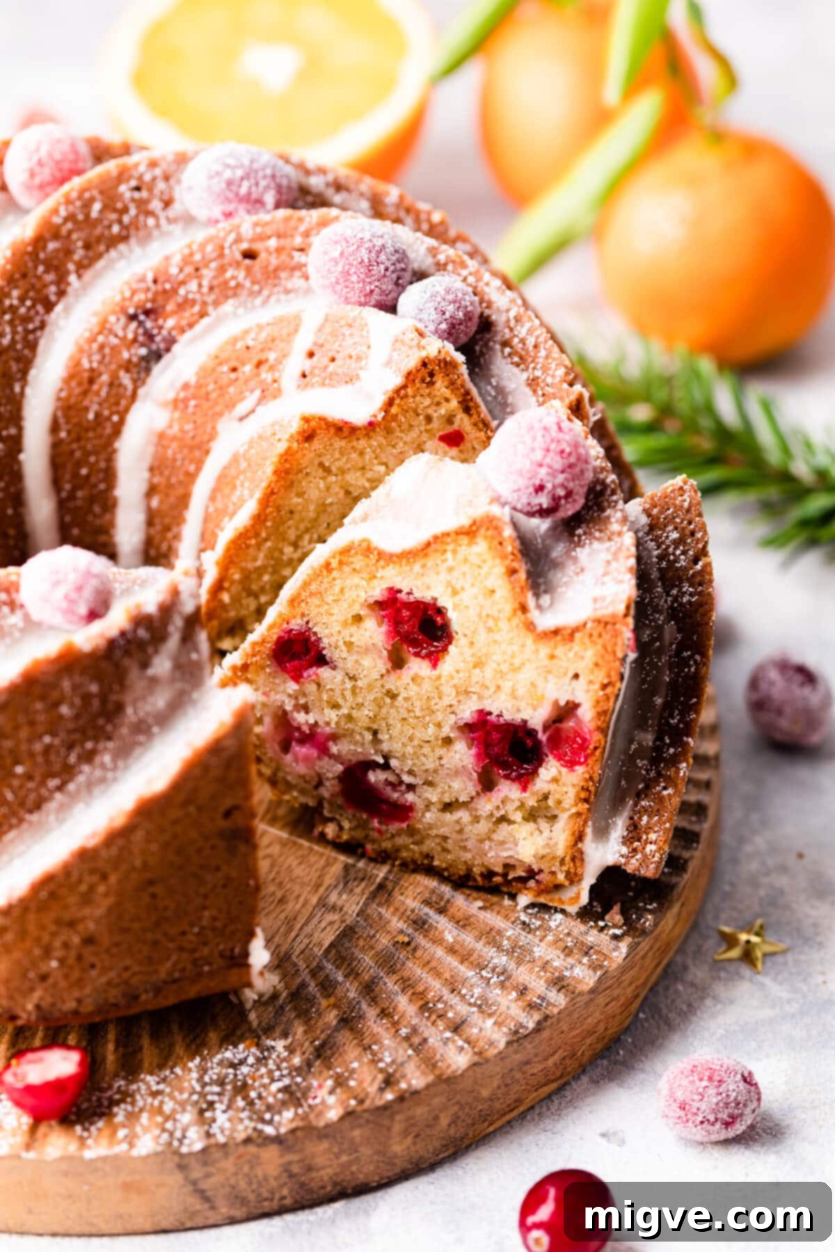 orange cranberry bundt cake with slice cut out of it.