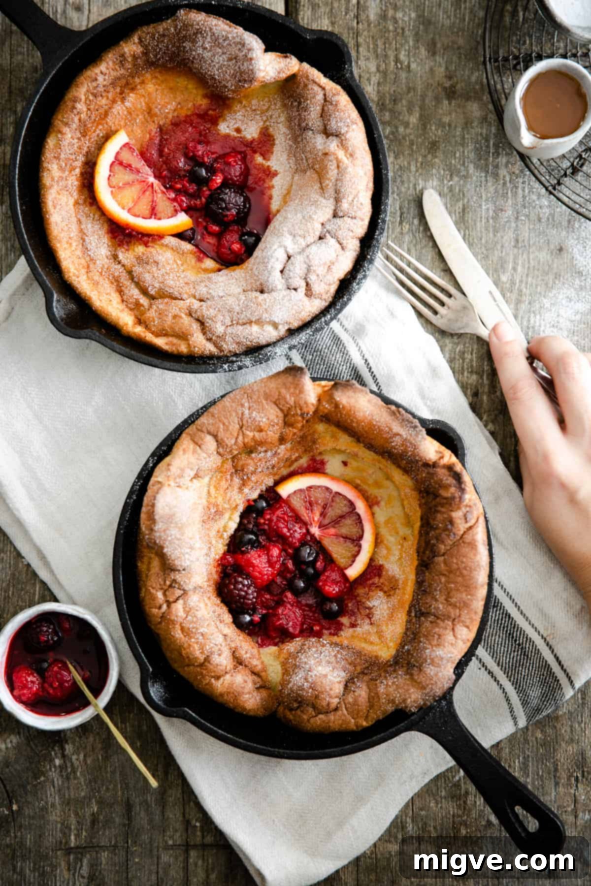 Berry Burst Dutch Delight 7 Overhead close up of two skillets with perfectly puffed Dutch baby pancakes inside