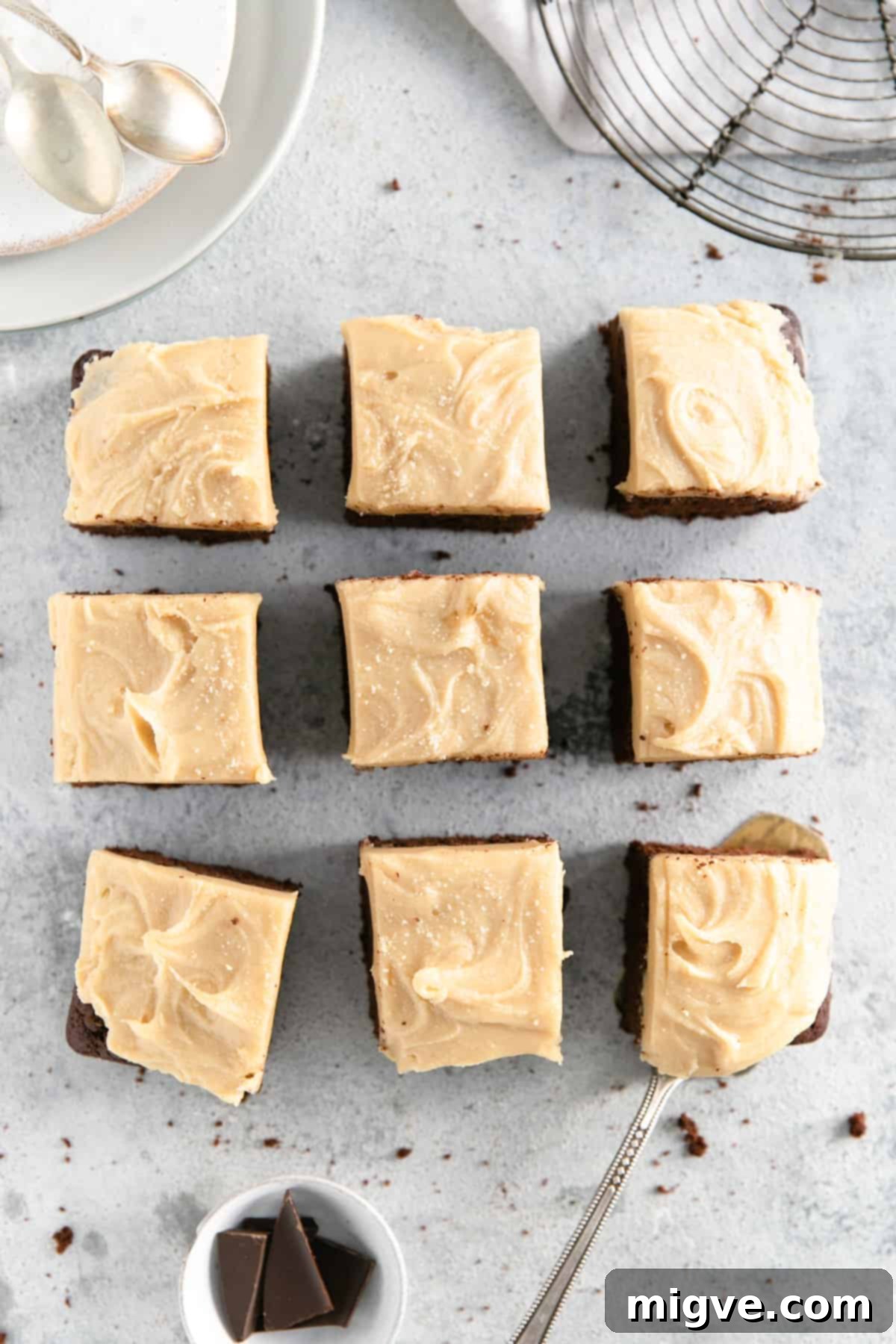 Overhead shot of nine square slices of chocolate brownies with peanut butter frosting