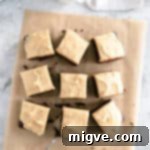 Overhead shot of chocolate brownies with peanut butter frosting on brown baking parchment