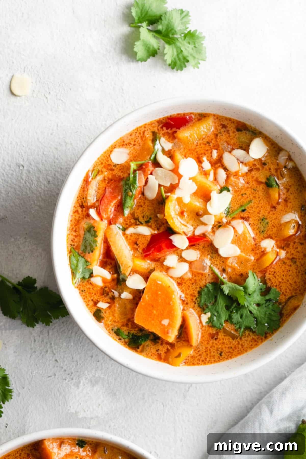 Golden Coconut Sweet Potato Curry 2 overhead shot of a single bowl with sweet potato curry topped with toasted almonds and coriander