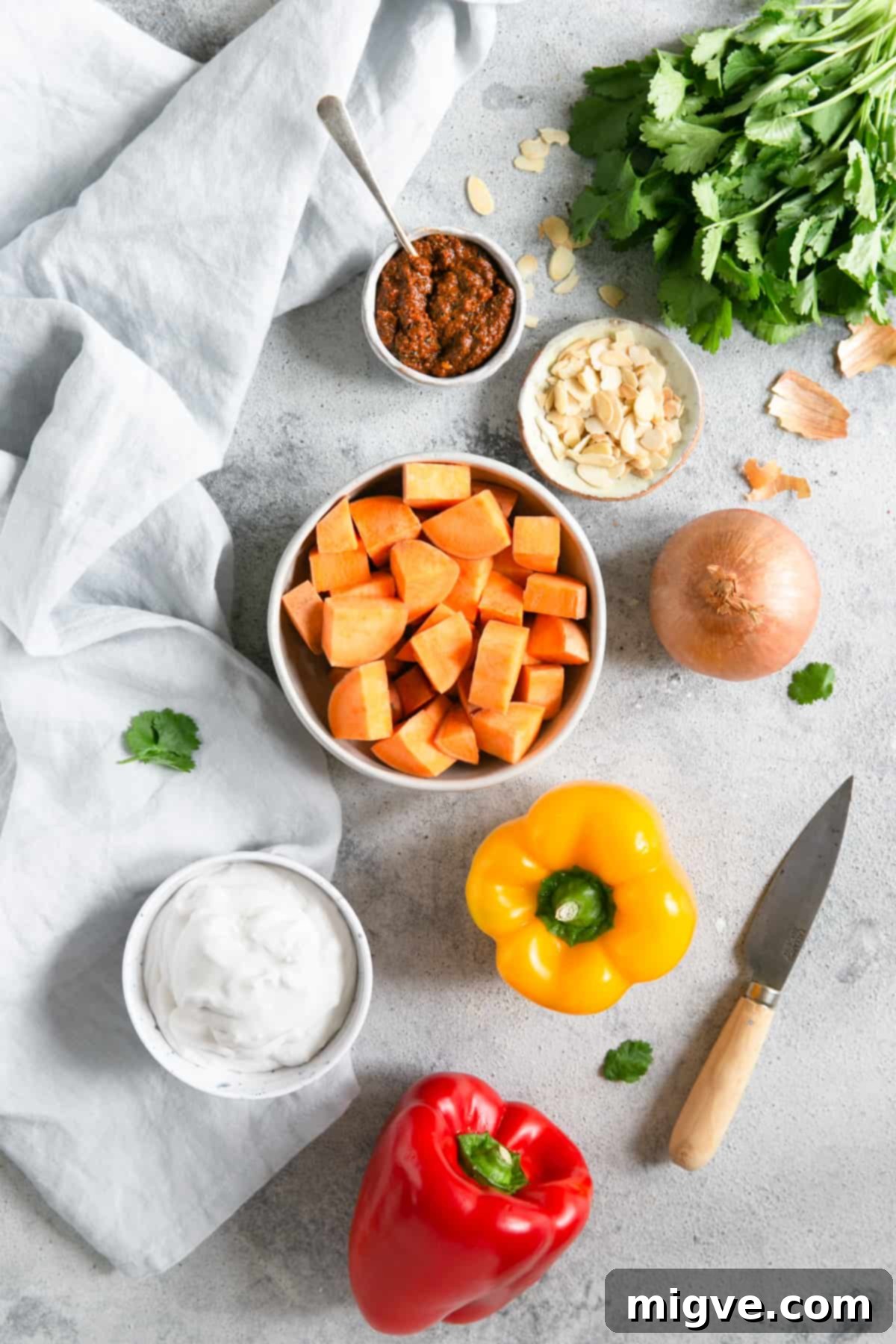 Golden Coconut Sweet Potato Curry 3 overhead shot of the ingredients for sweet potato curry; peppers, coconut milk, sweet potato, onion, toasted almonds, coriander, curry paste