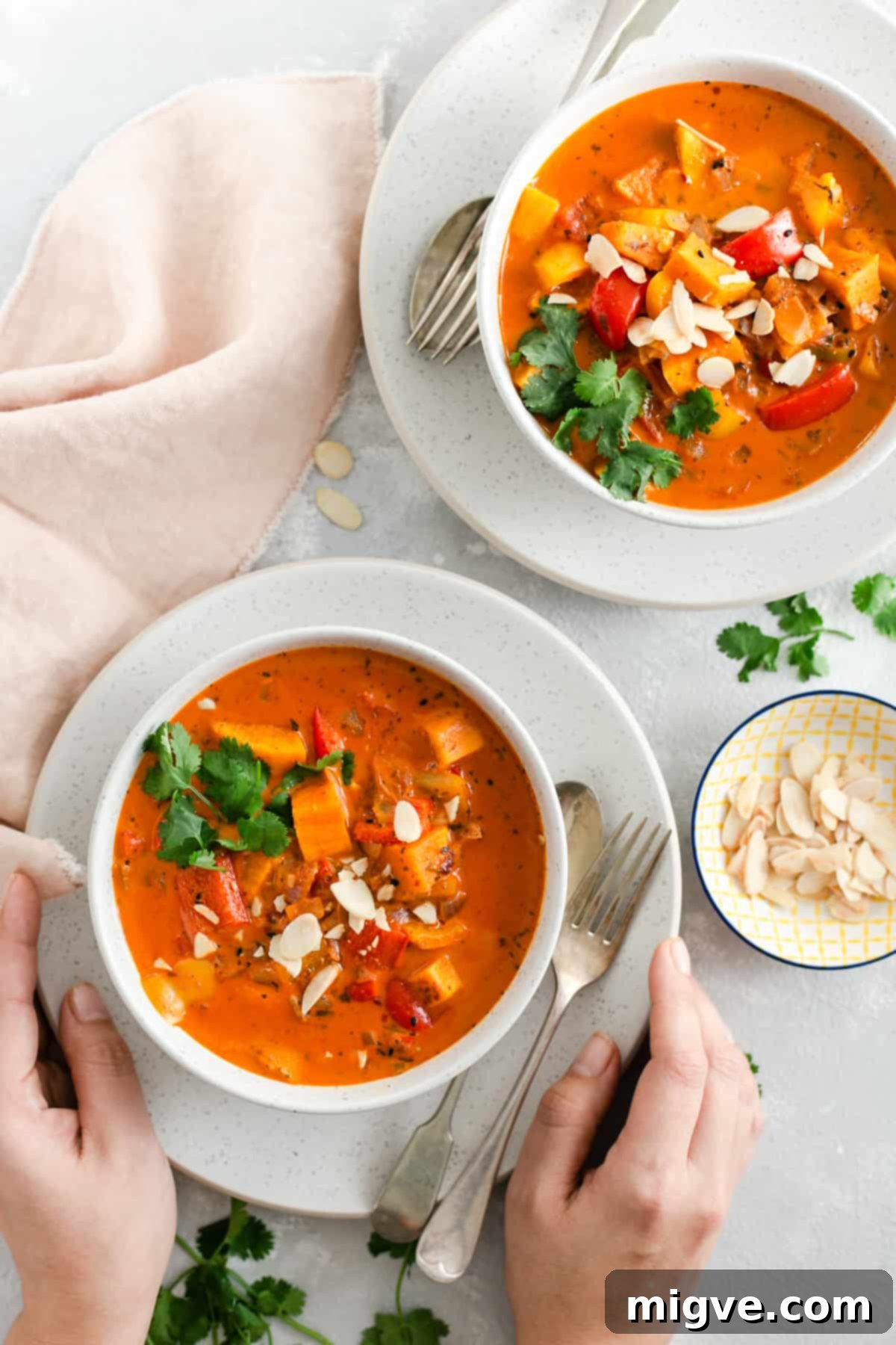 Golden Coconut Sweet Potato Curry 7 overhead shot of two bowls with sweet potato curry and side dish with toasted almonds