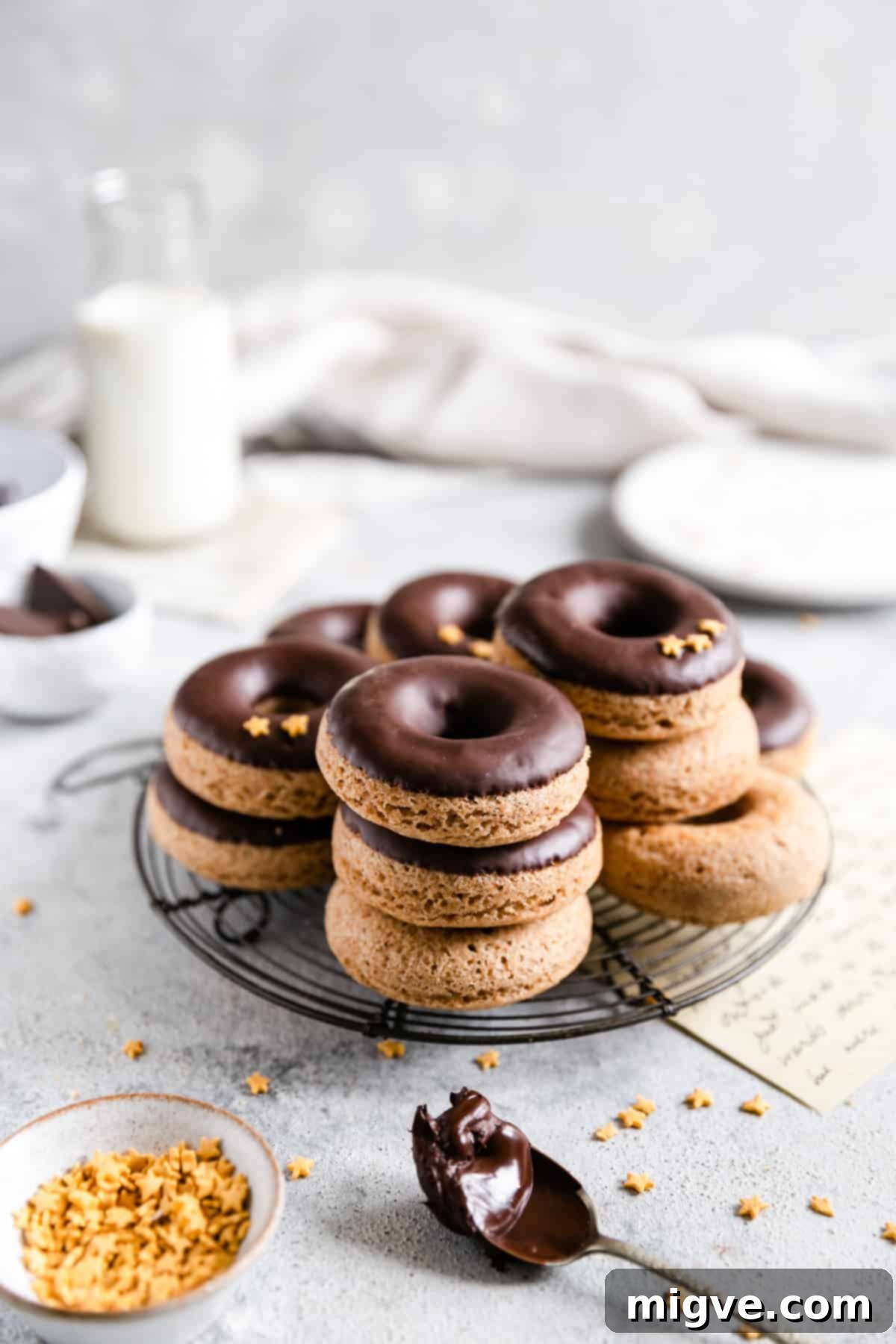 Straight ahead shot of baked doughnuts with chocolate glaze on a round cooling rack