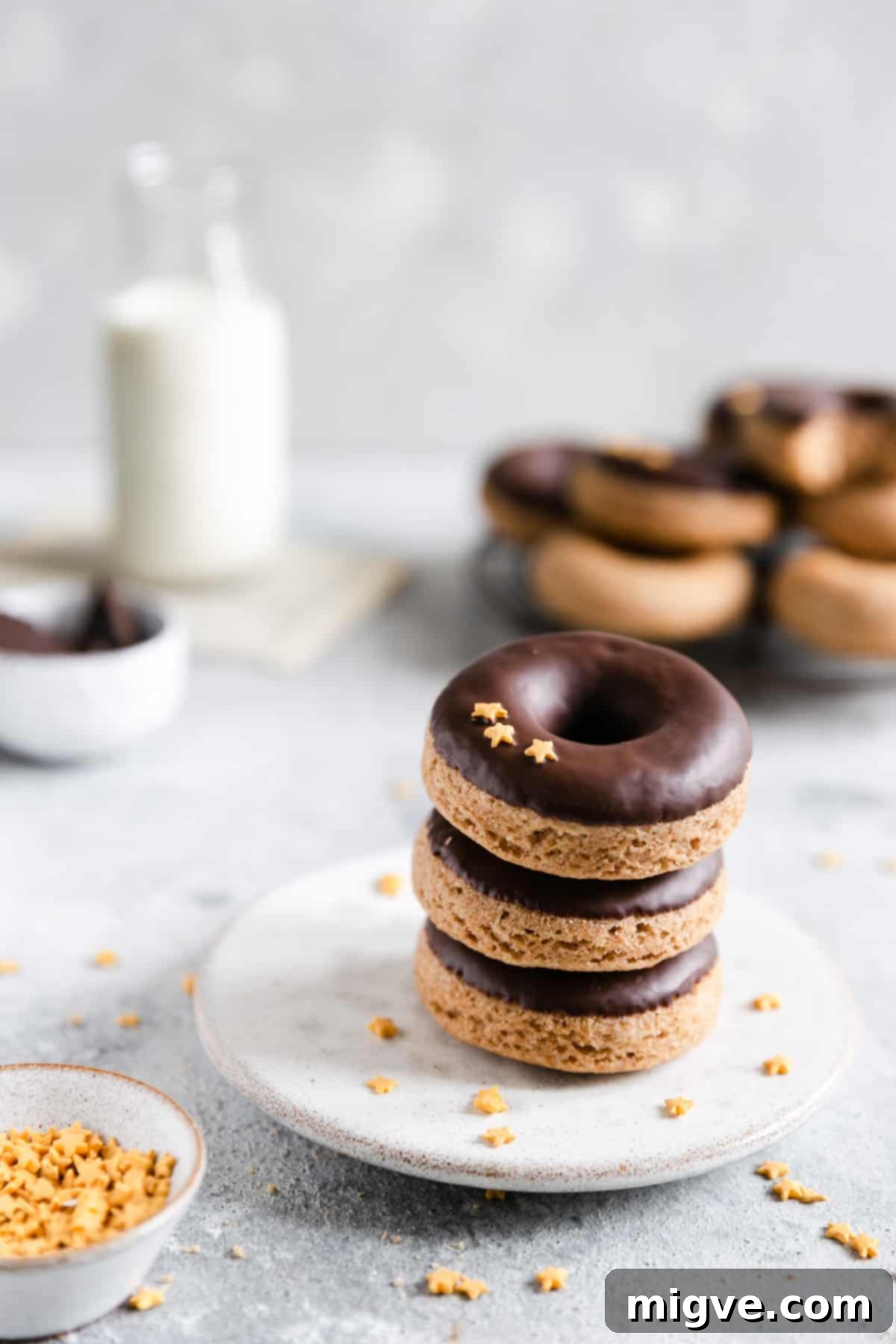 straight ahead shot of 3 baked doughnuts on a small plate stacked together