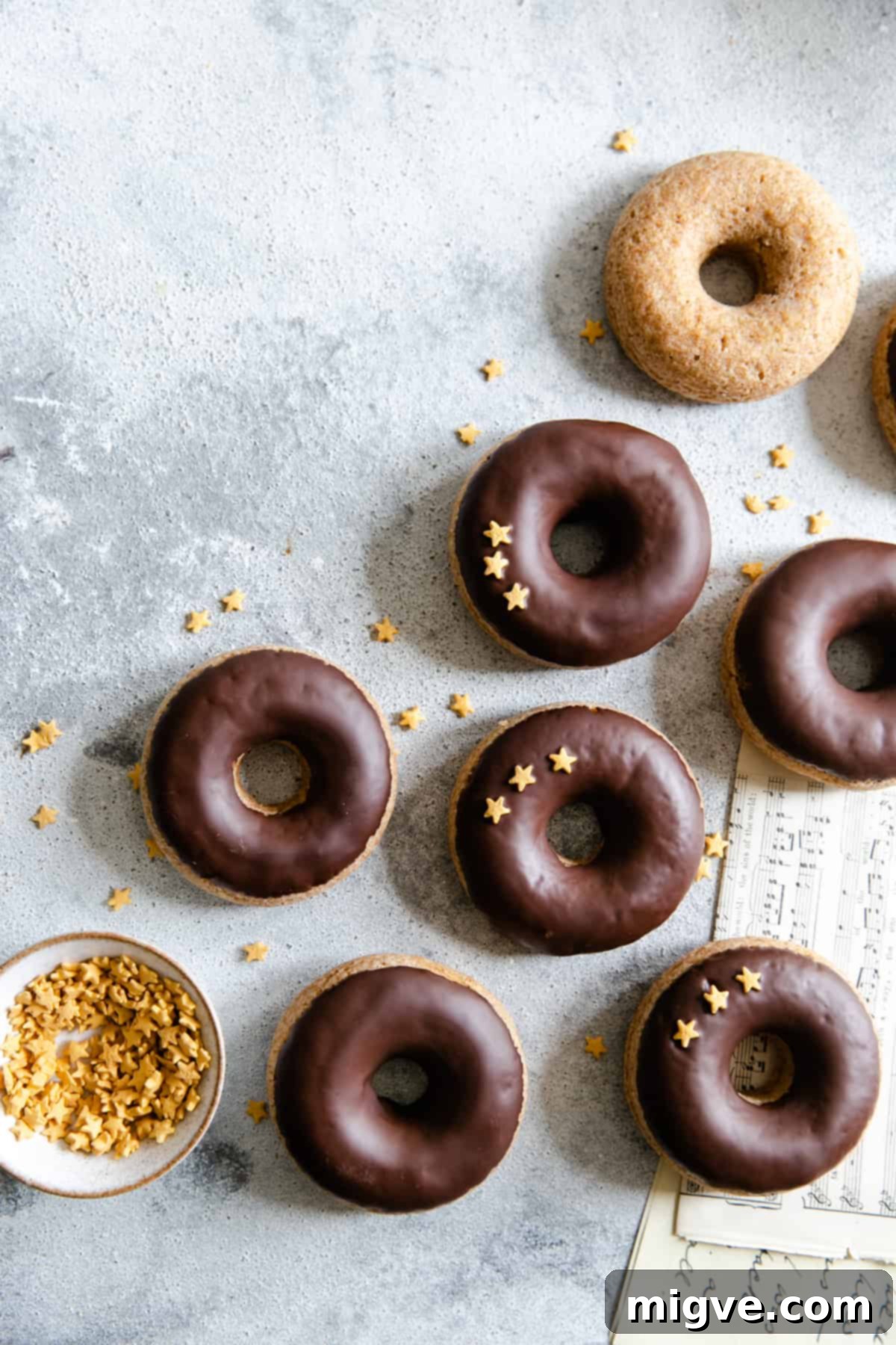 overhead shot of baked doughnuts with chocolate glaze and star-shaped sprinkles