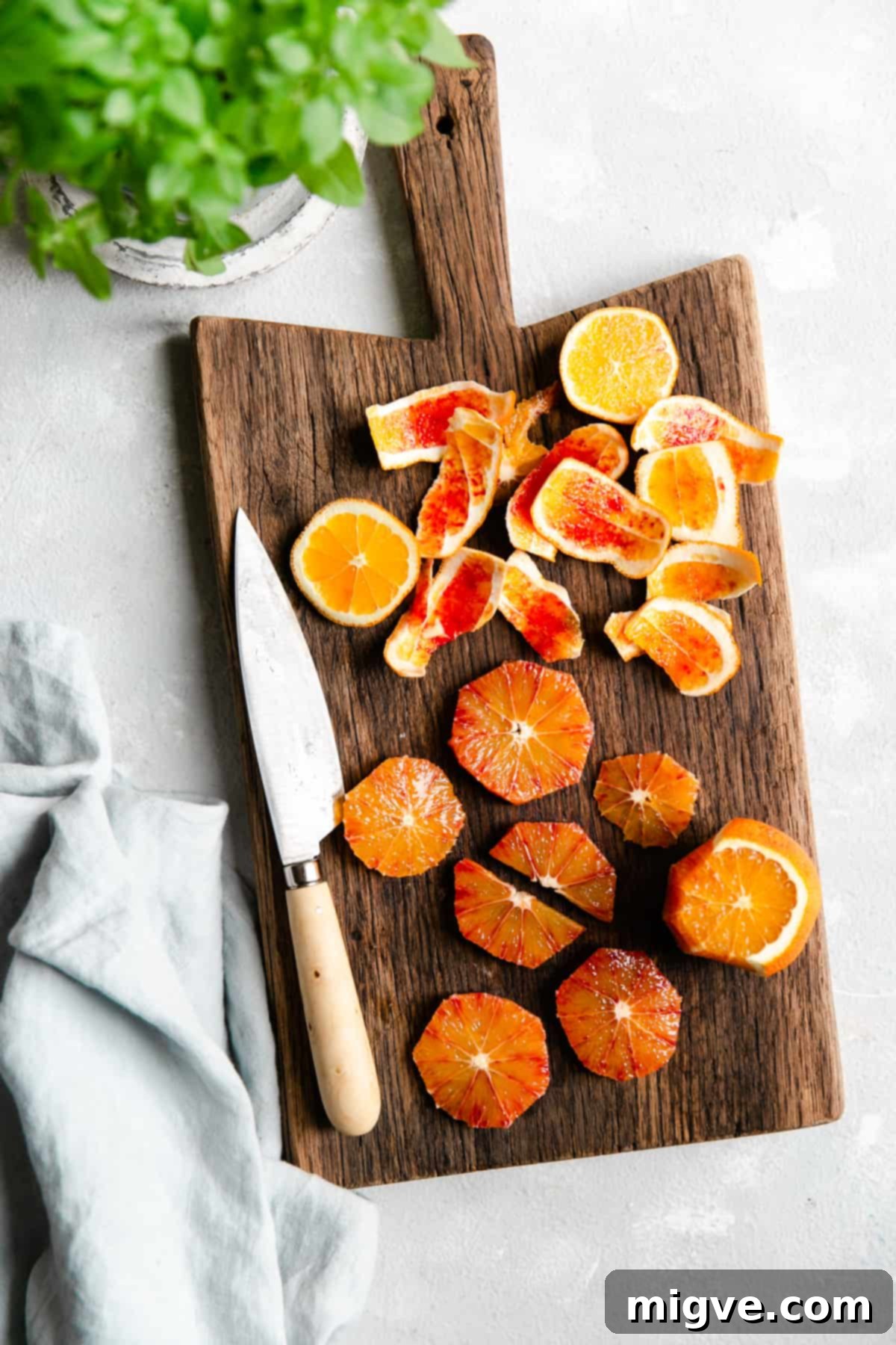 Close-up shot of fresh blood orange slices arranged on a rustic wooden chopping board