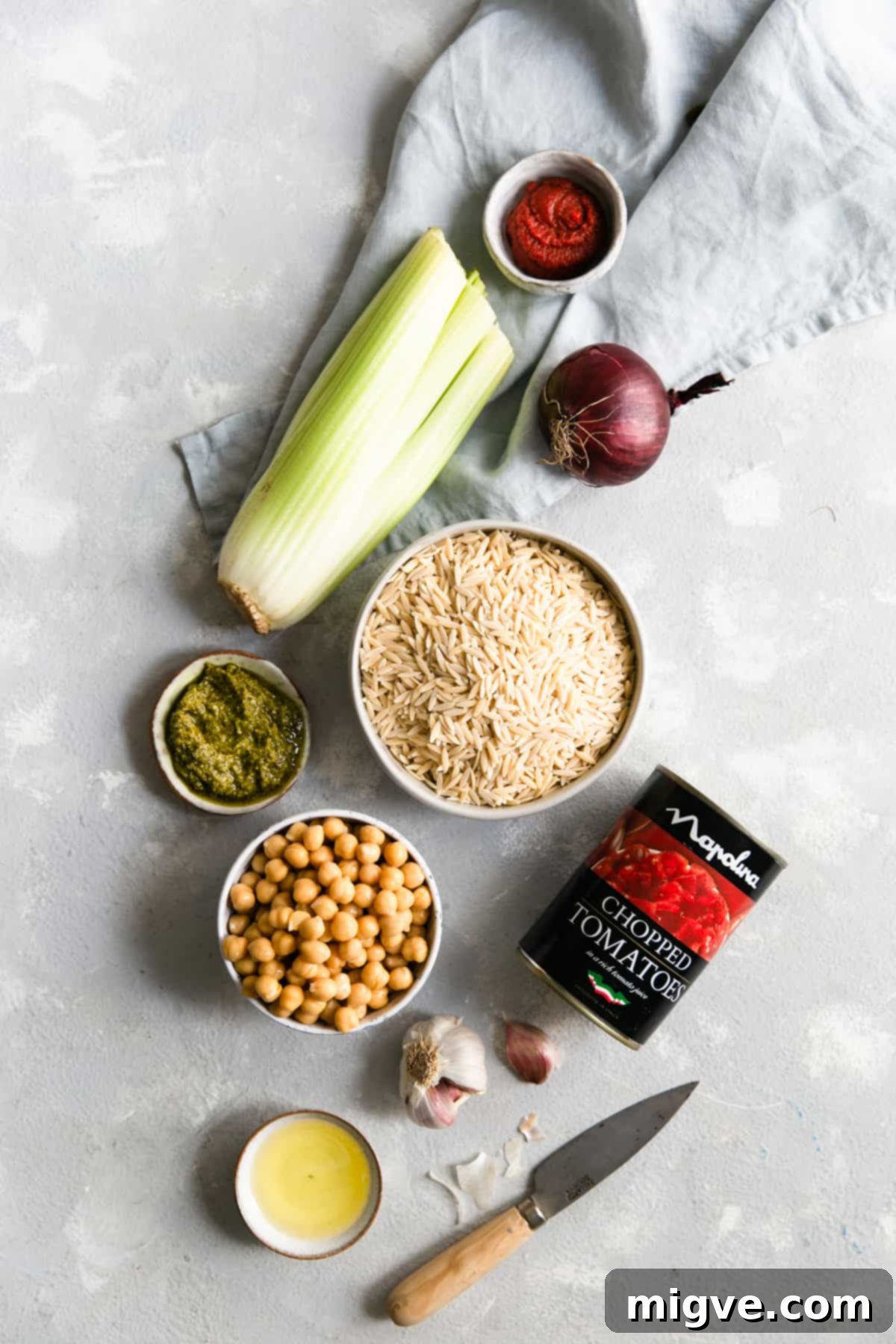 Overhead shot showcasing a vibrant array of fresh ingredients laid out for Orzo and Tomato Soup preparation