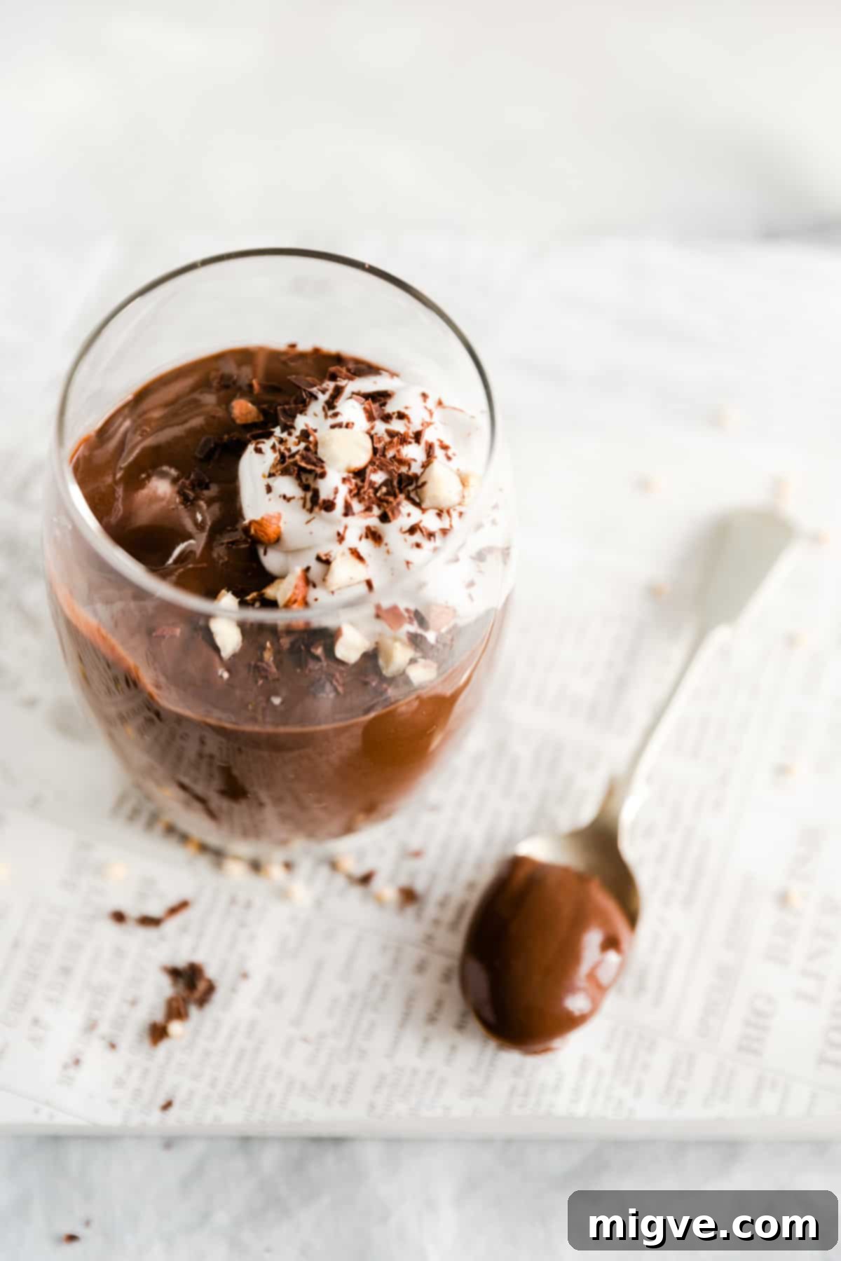single glass with vegan chocolate pudding and spoonful of pudding on site