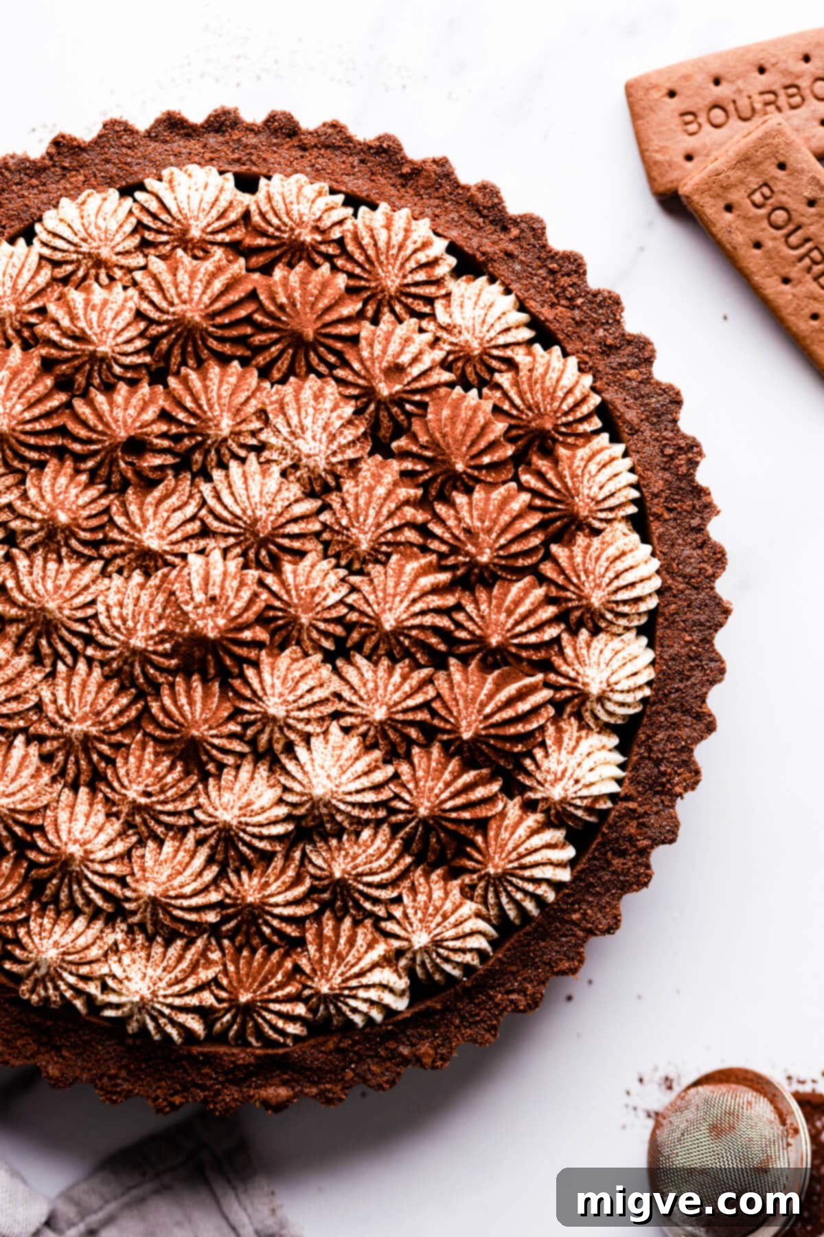 Overhead close up of vegan banoffee pie topped with whipped cream and dusted with cocoa