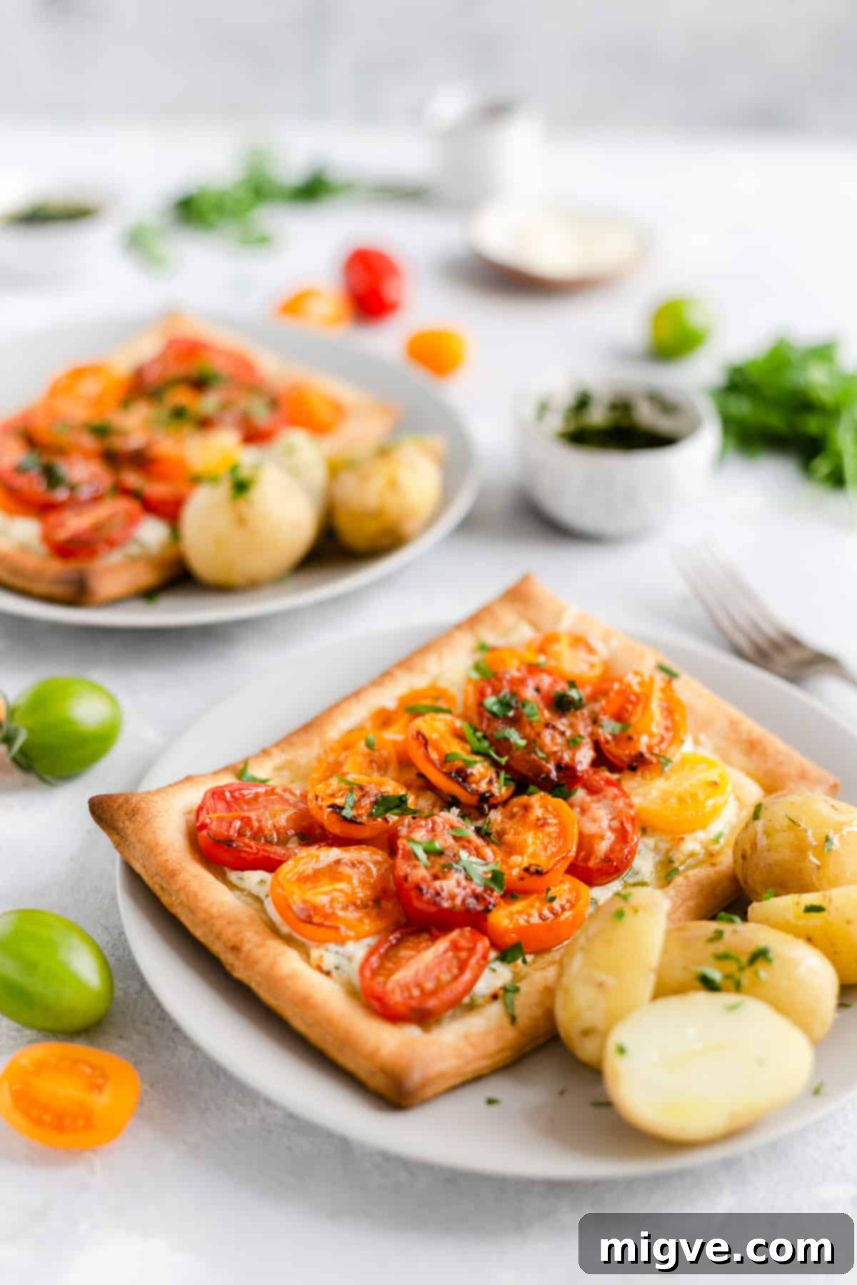 Vibrant Tomato & Savory Cheese Tartlets 2 A single, perfectly baked mixed tomato and cheese tartlet presented alongside a portion of cooked new potatoes, ready to be served.