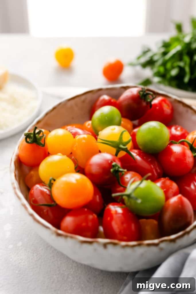 Vibrant Tomato & Savory Cheese Tartlets 11 A straight-ahead close-up of a bowl brimming with mixed baby plum tomatoes, showcasing their vivid colors and fresh appearance.
