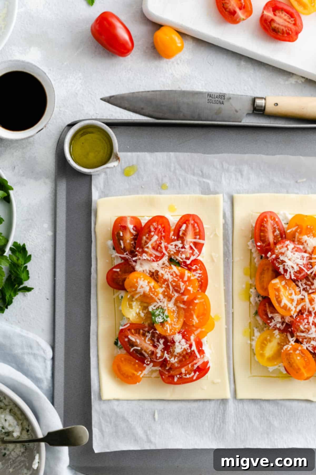 Vibrant Tomato & Savory Cheese Tartlets 8 Overhead close-up of unbaked mixed tomato and cheese tartlets, beautifully sprinkled with a final layer of finely grated cheese before baking.
