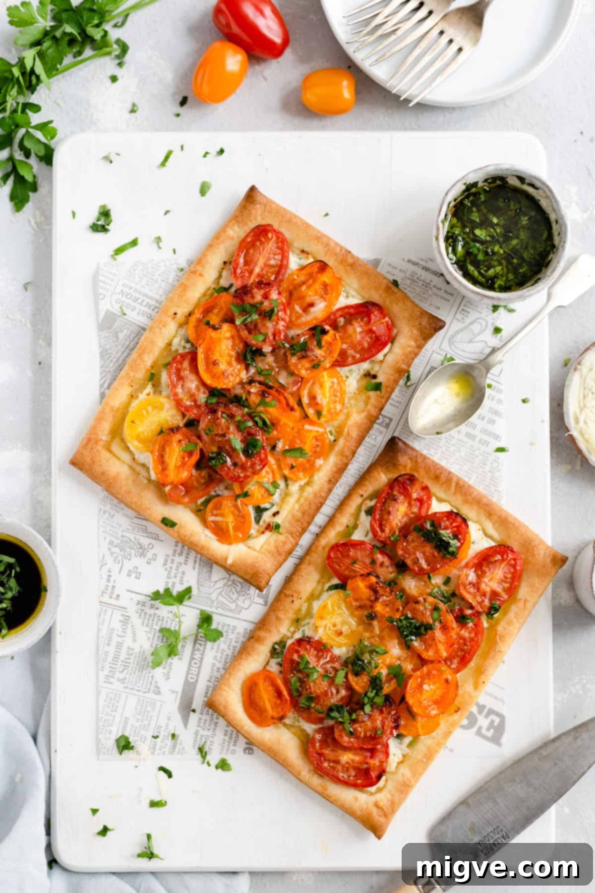 Vibrant Tomato & Savory Cheese Tartlets 9 Overhead shot of freshly baked mixed tomato and cheese tartlets, golden brown and garnished with fresh parsley, served with a side of balsamic parsley dressing.