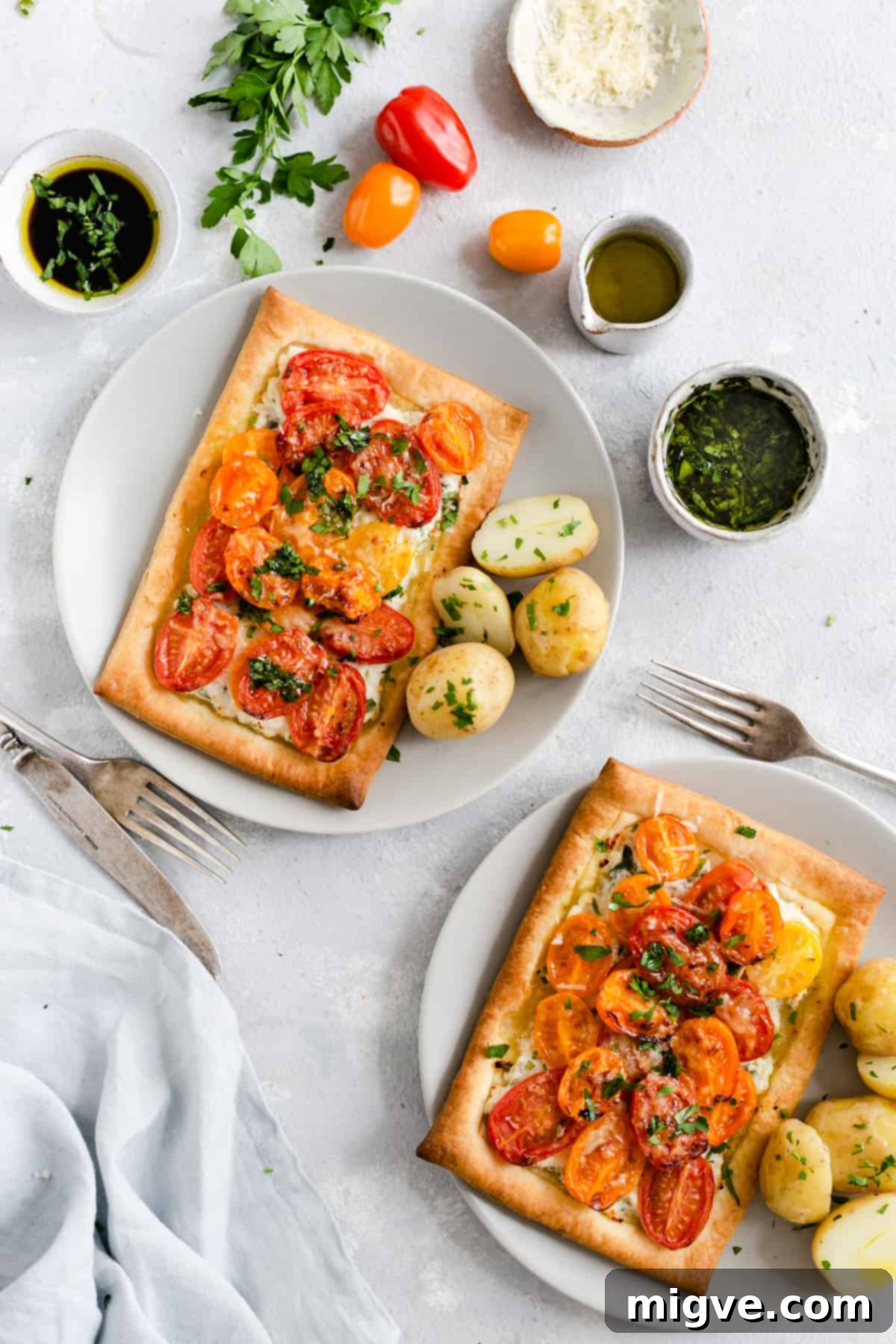 Vibrant Tomato & Savory Cheese Tartlets 10 Overhead shot displaying two individual mixed tomato and cheese tartlets, beautifully golden, accompanied by cooked new potatoes for a complete meal.