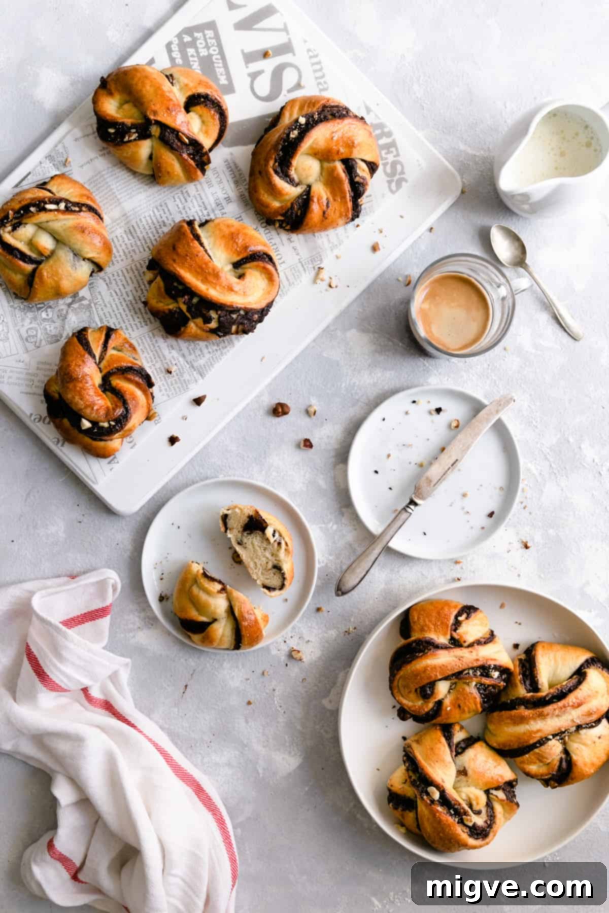 Swirled Chocolate Hazelnut Babka Buns 9 Overhead shot of several freshly baked chocolate hazelnut babka buns artfully arranged with a small cup of coffee on the side, ready to be enjoyed.