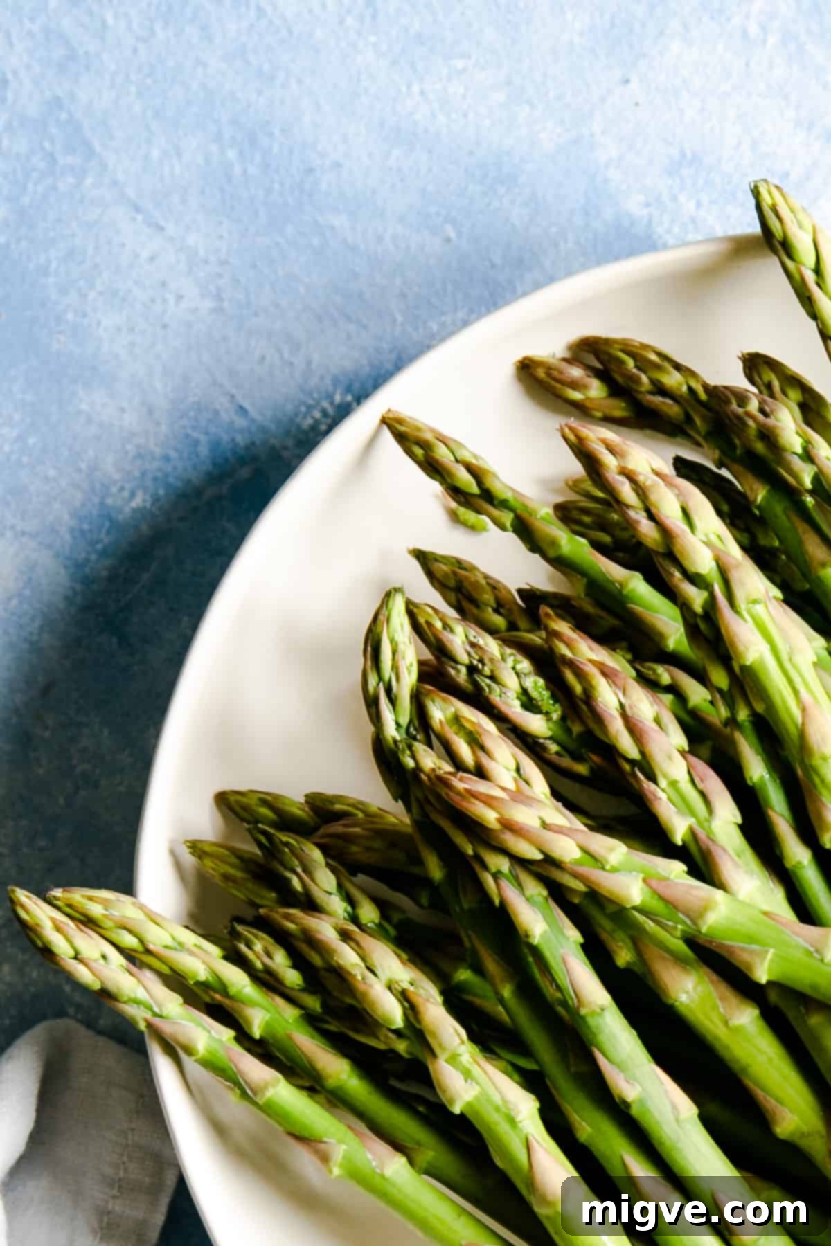 close up of the green asparagus tips in a white plate