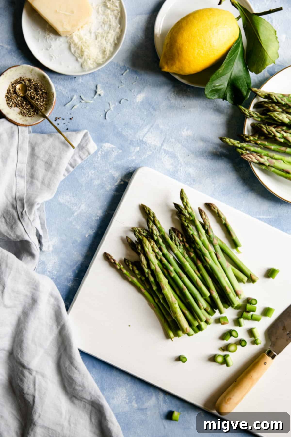 overhead shot of chopped asparagus on a white chopping board