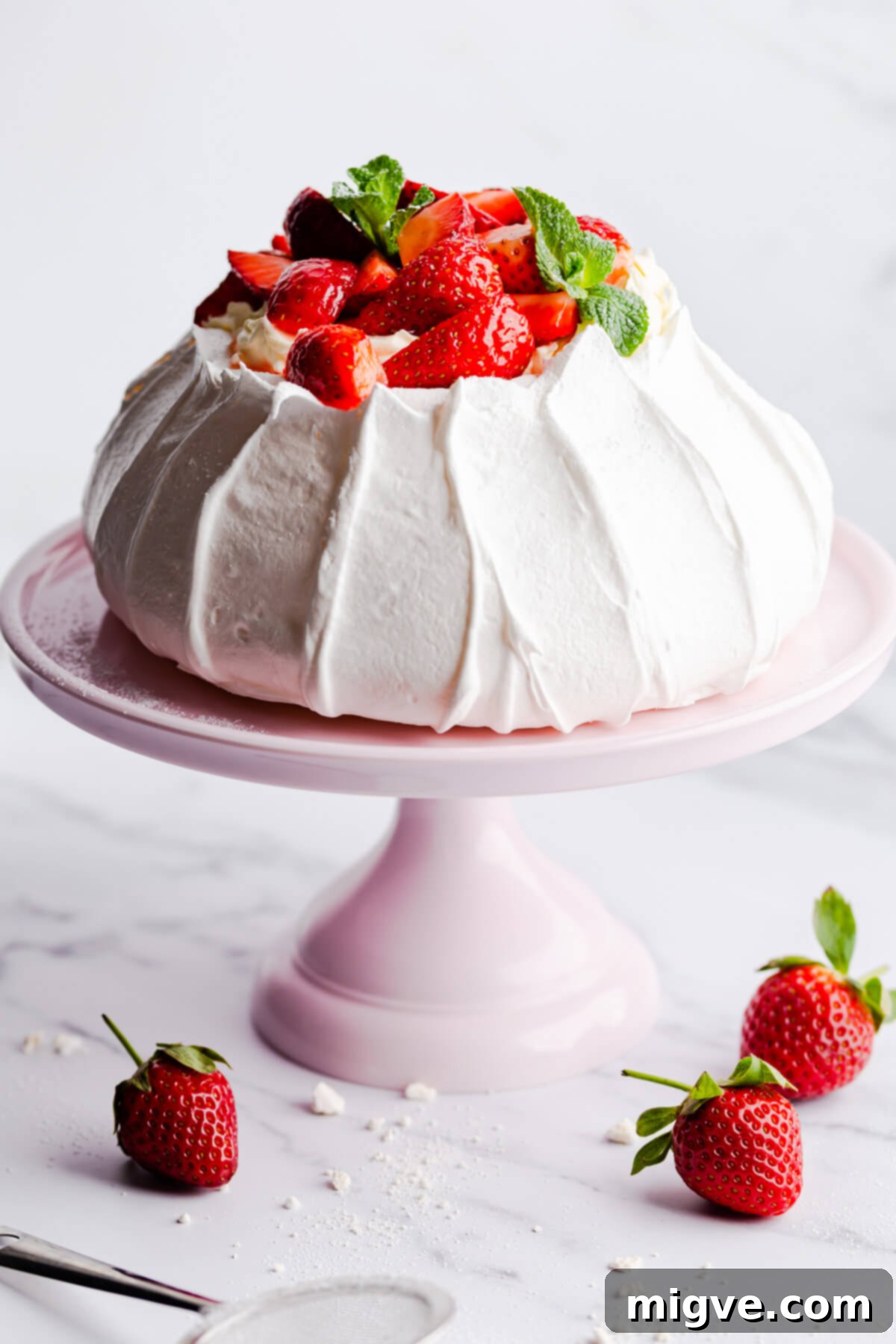 Side close-up of a perfectly baked strawberry pavlova, generously topped with whipped cream and fresh, ripe strawberries, ready to be served
