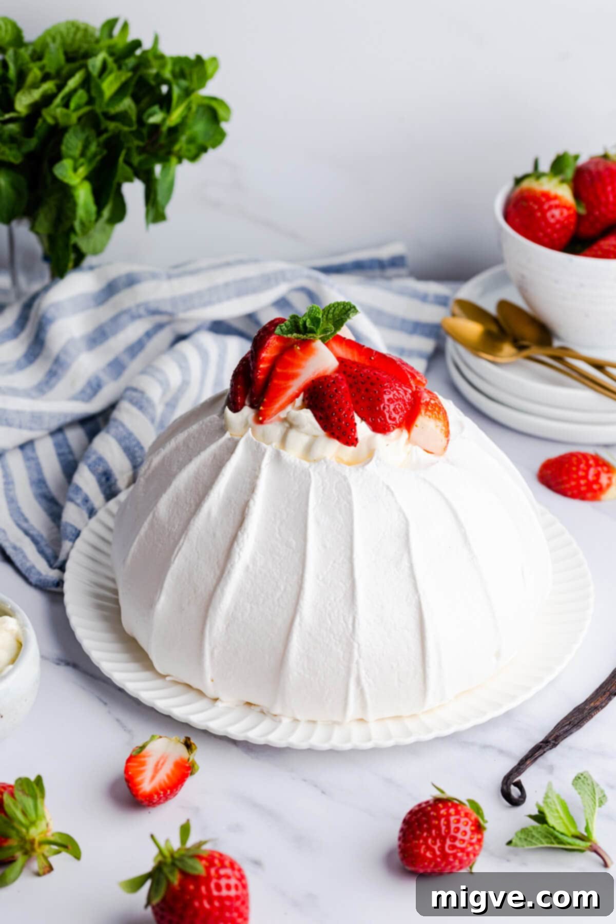 A simple side view of a perfectly proportioned pavlova meringue shell on a white plate, ready for its delicious toppings