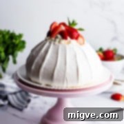 45 degree angle view of the strawberry pavlova on pink cake stand