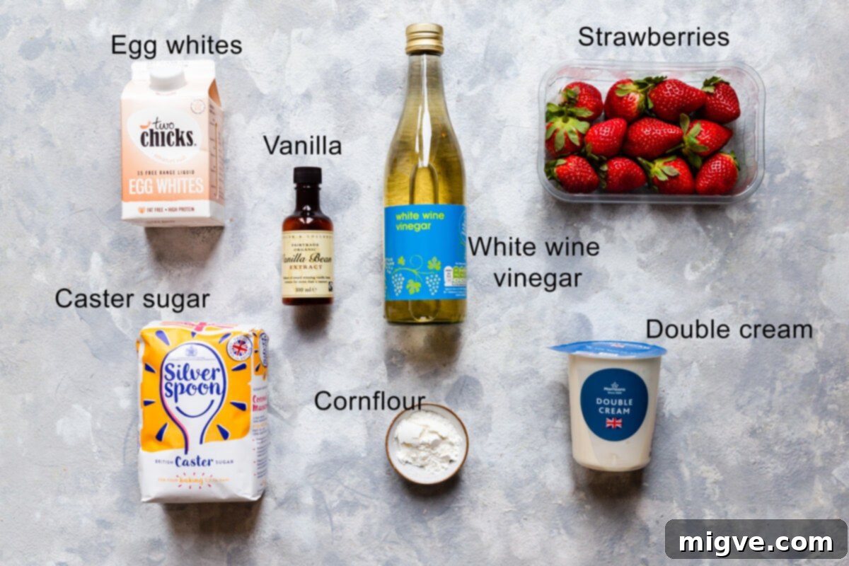 Top-down view of all the essential ingredients for strawberry pavlova laid out on a surface, clearly labeled for easy identification