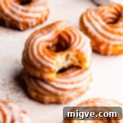 Airy Choux Rings 11 A side close-up of a stack of two crullers with the top one missing a bite
