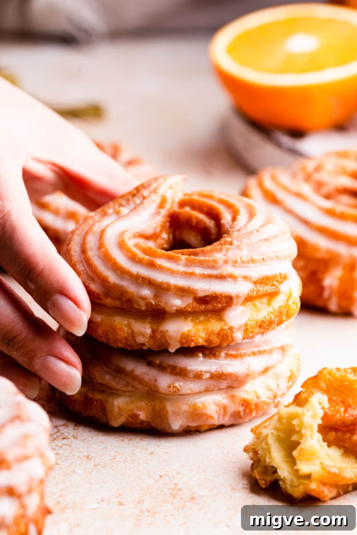 Airy Choux Rings 8 Super close-up side view of two perfectly glazed French cruller doughnuts stacked on top of each other, showcasing their intricate ridged texture.