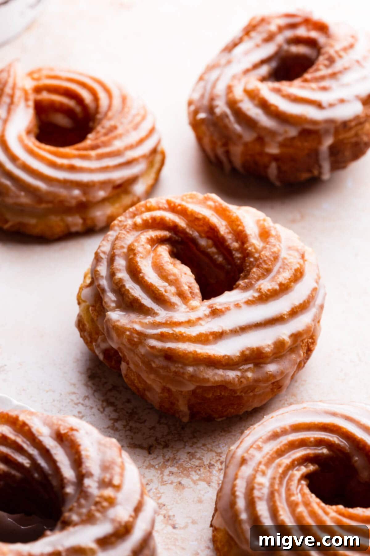 Airy Choux Rings 10 45-degree angle close-up view of multiple choux pastry doughnuts, beautifully dipped in a sweet glaze and arranged appealingly.