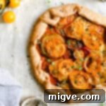 overhead shot of summer tomato galette topped with fresh thyme and black pepper