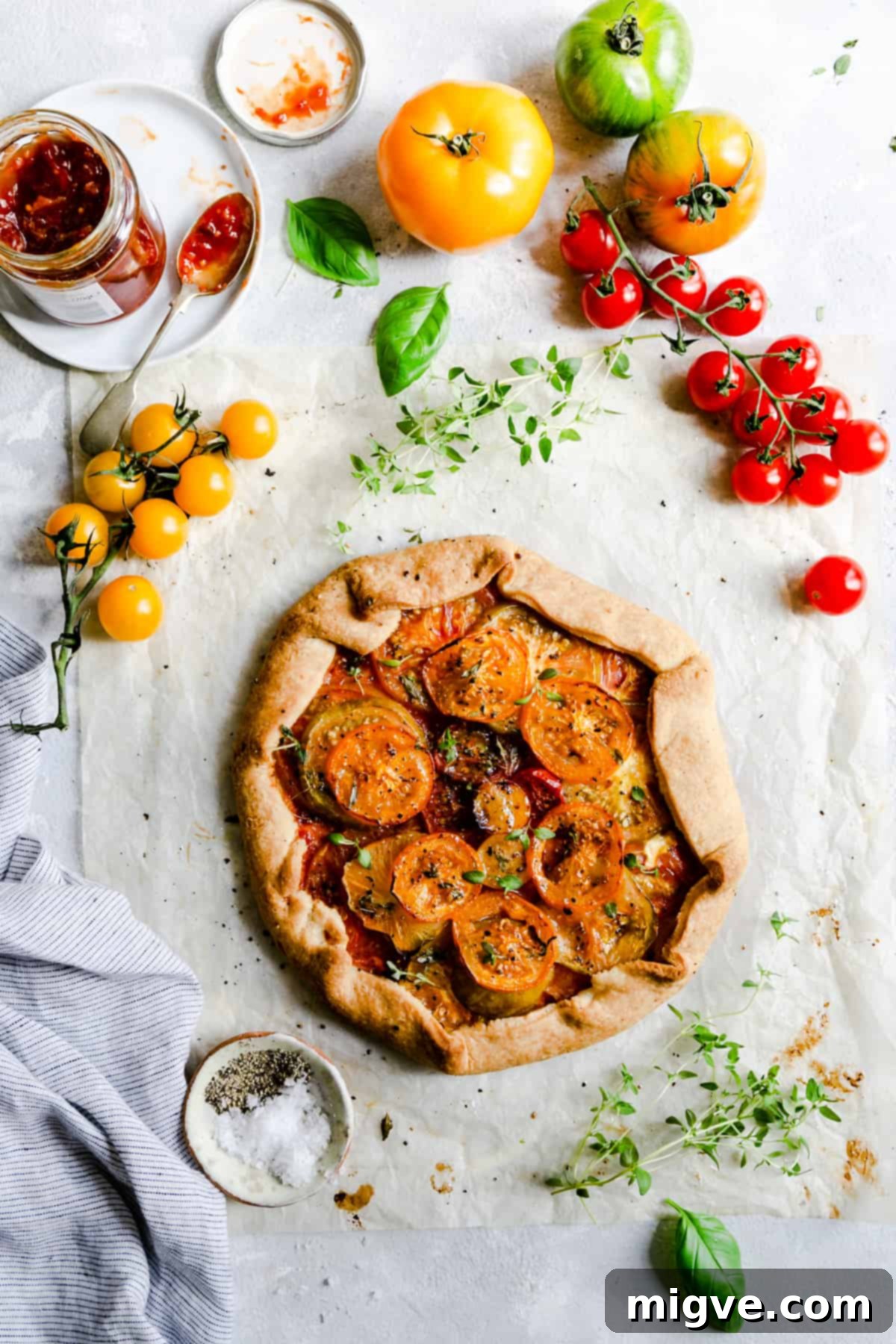 top view of a beautifully baked summer tomato galette, garnished with fresh thyme leaves, ready to be served