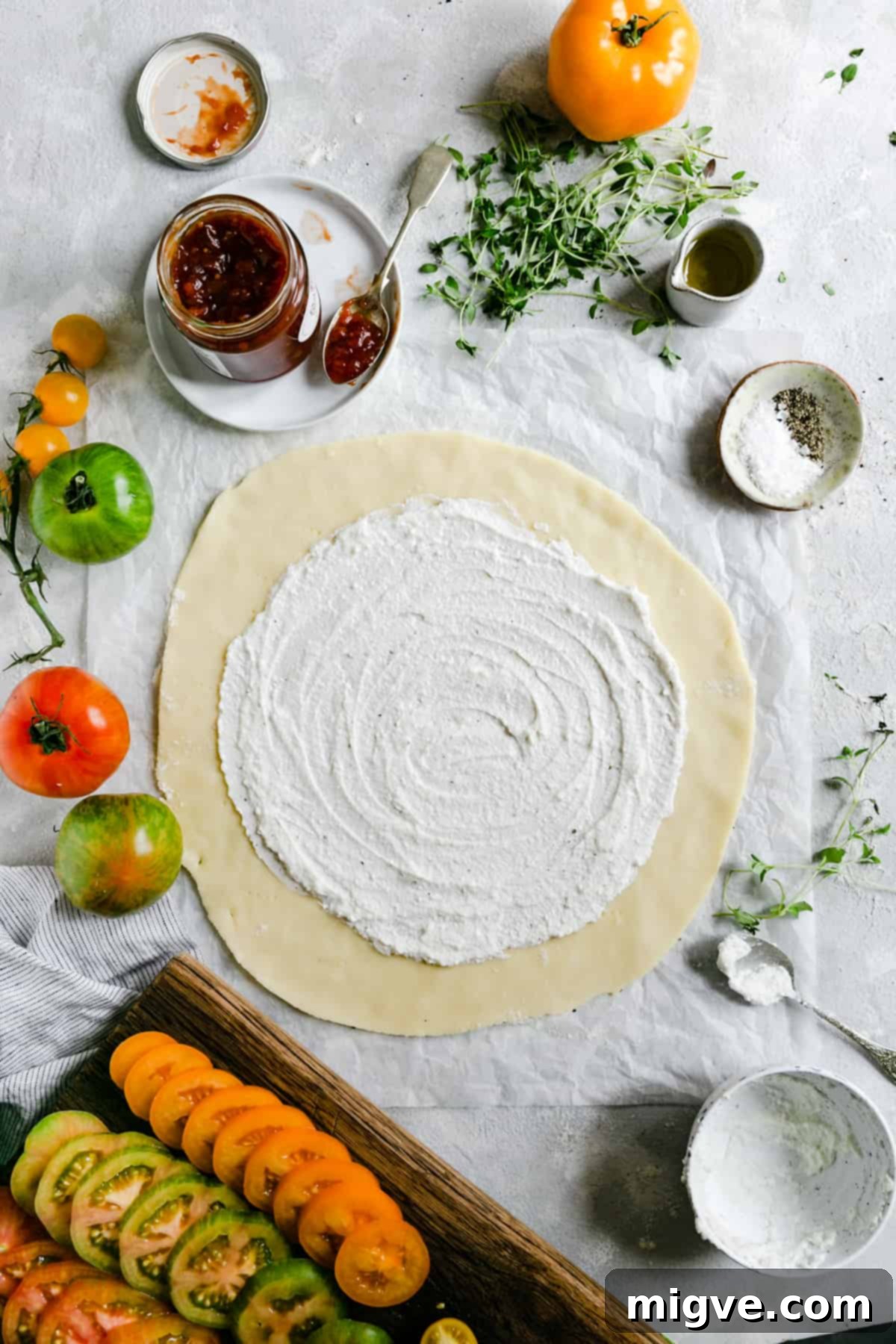 top view of a golden shortcrust pastry circle, delicately pricked and topped with a creamy layer of ricotta cheese