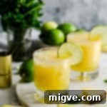 two glasses filled with pineapple margarita cocktail