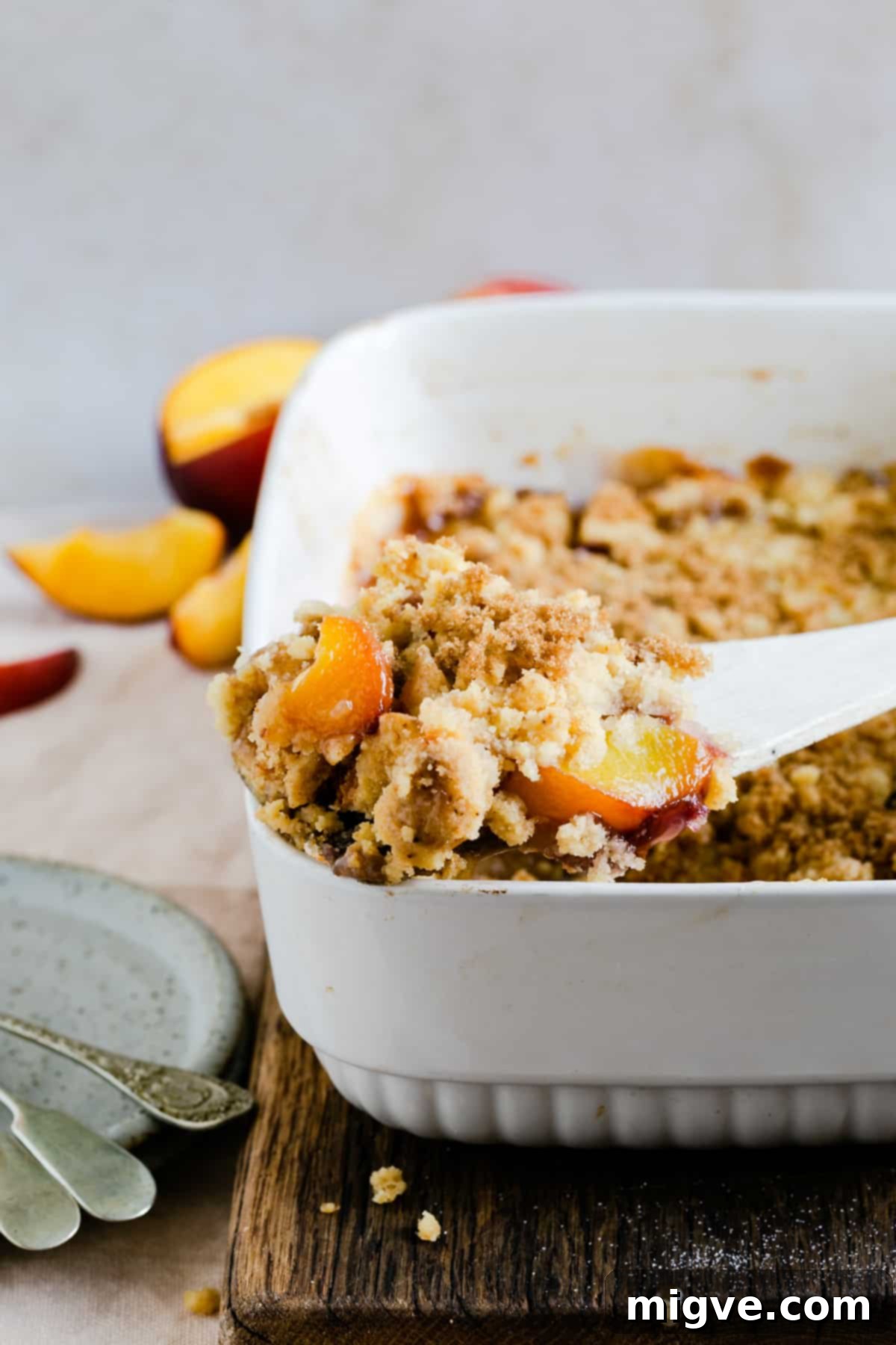 close up of freshly baked peach cobbler with golden topping and bubbly fruit